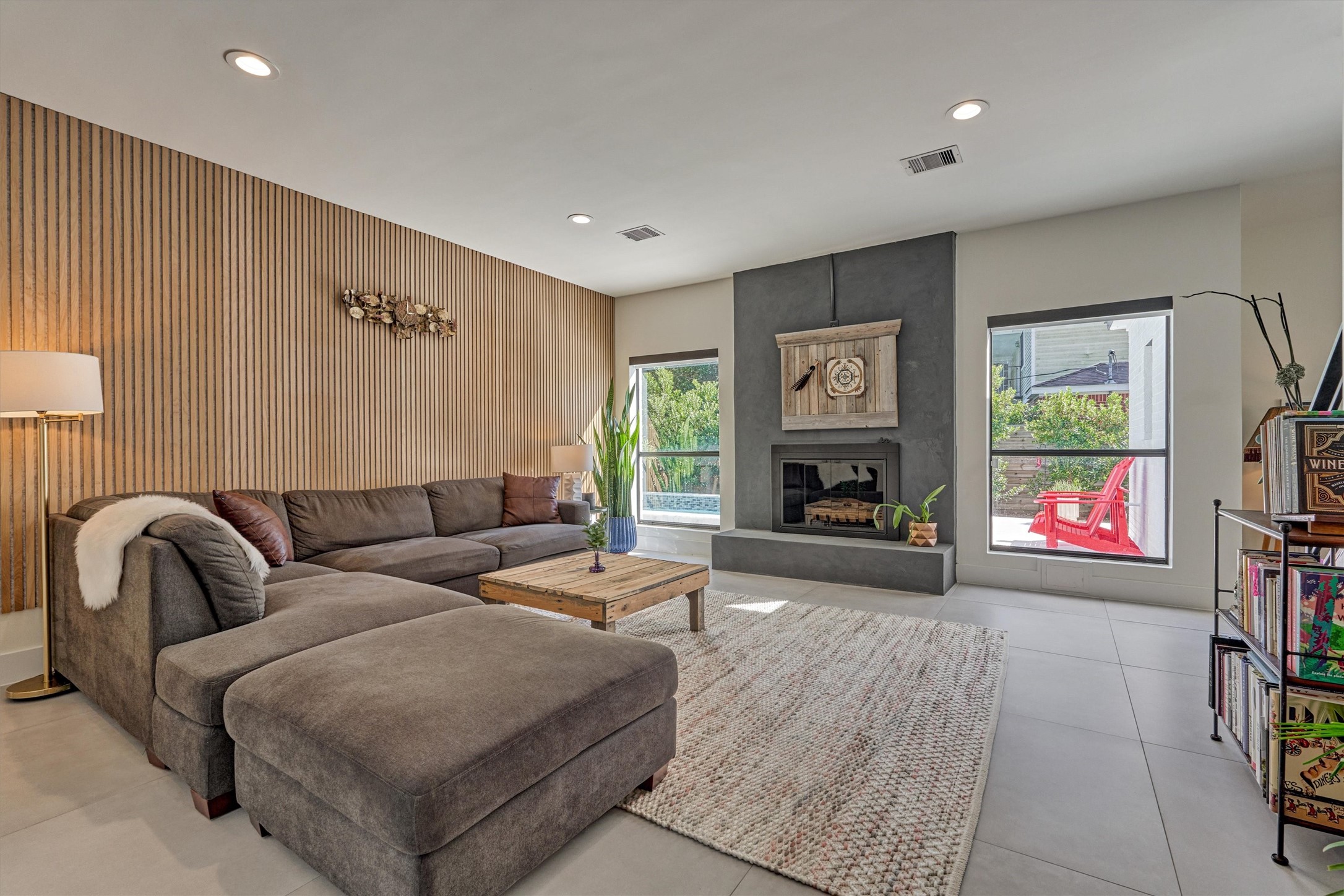 Relax in this oversized den with limewash fireplace, custom paneling, and sweeping backyard views!