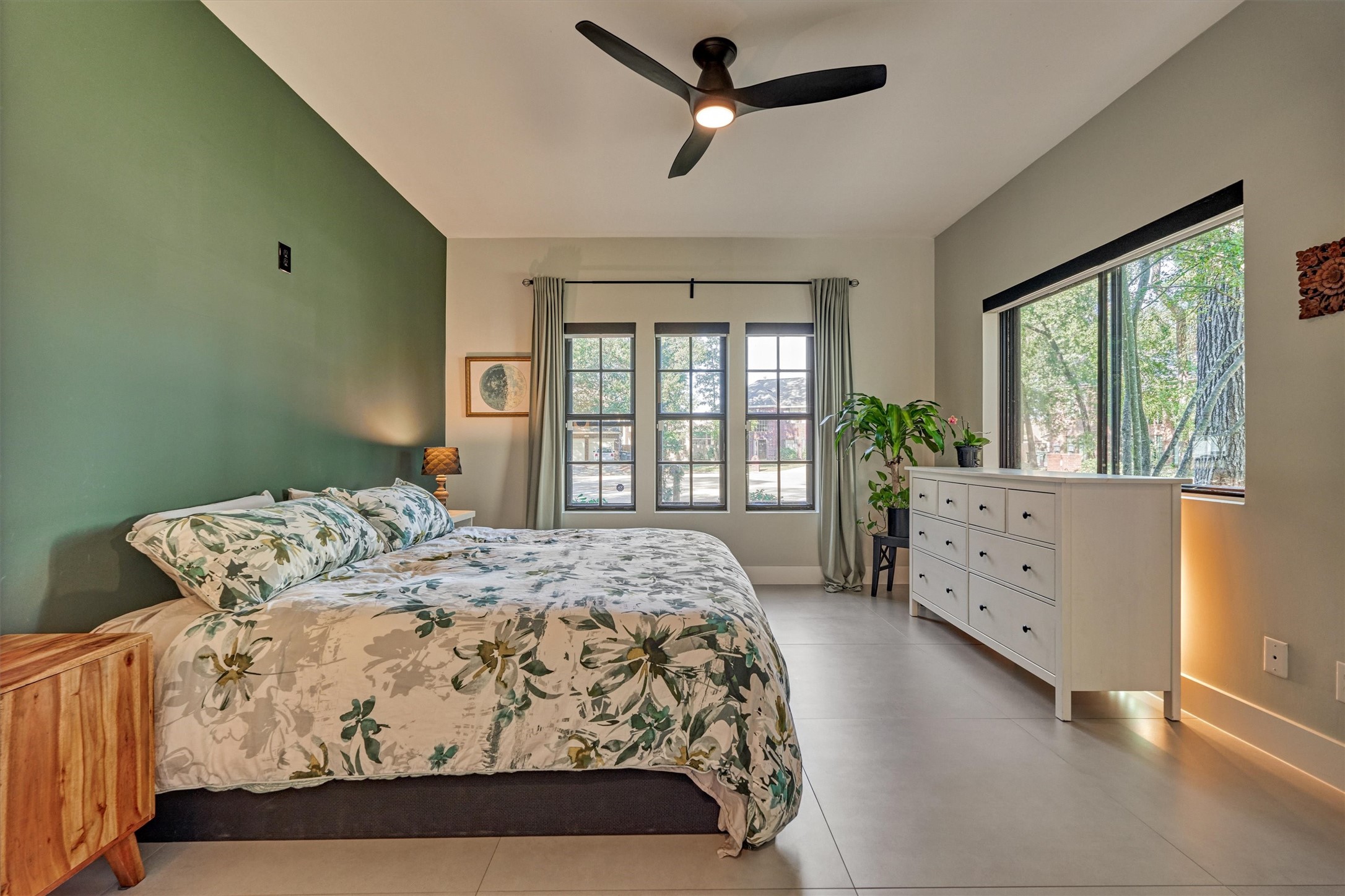 Light and bright, this large owner's retreat offers continuous tile flooring, wooded views, and complementary color palette. Note the upgraded ceiling fan for added comfort.