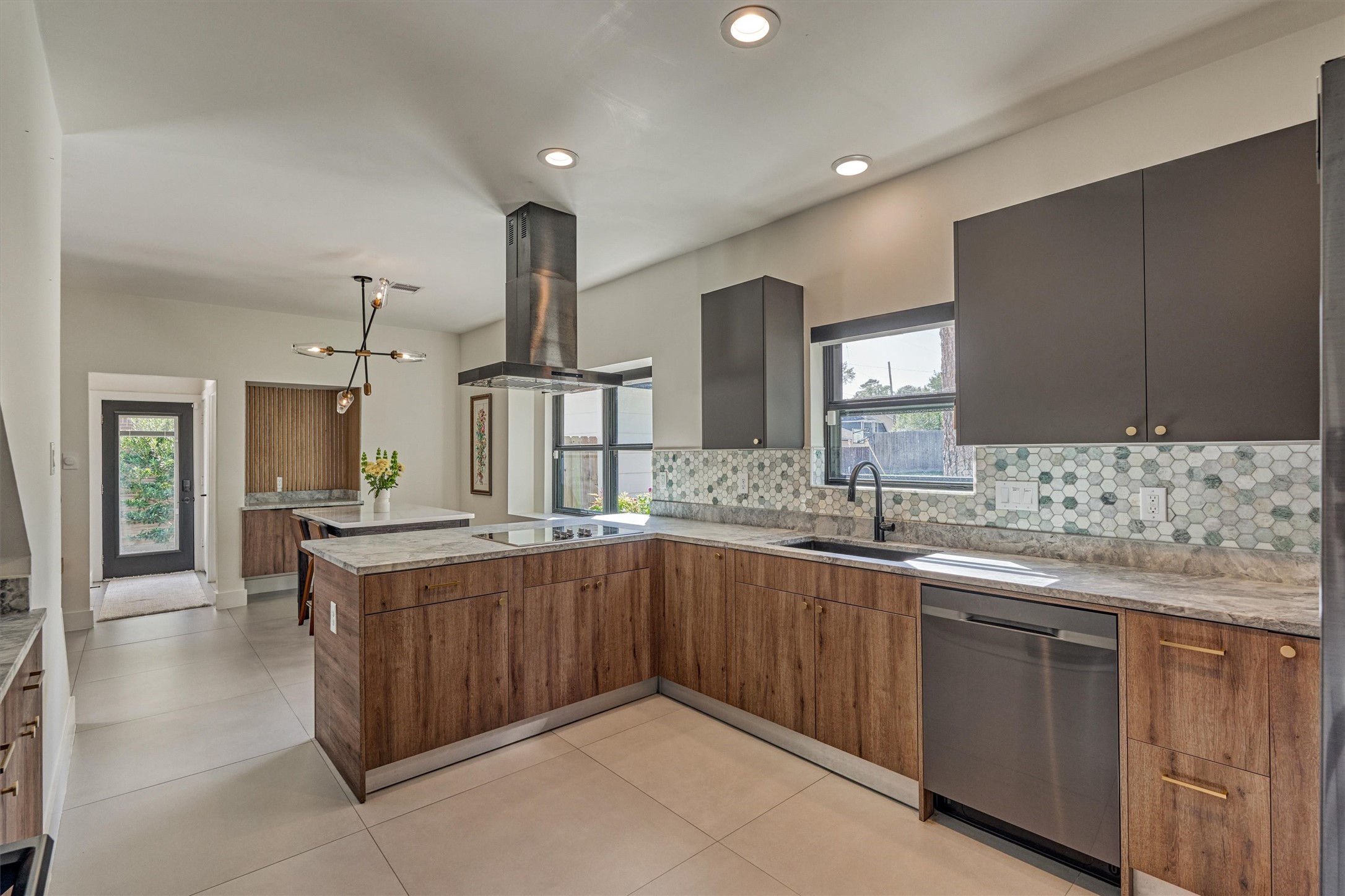 Two-toned cabinets with gold hardware align beautifully alongside the marble backsplash and stainless appliance package.