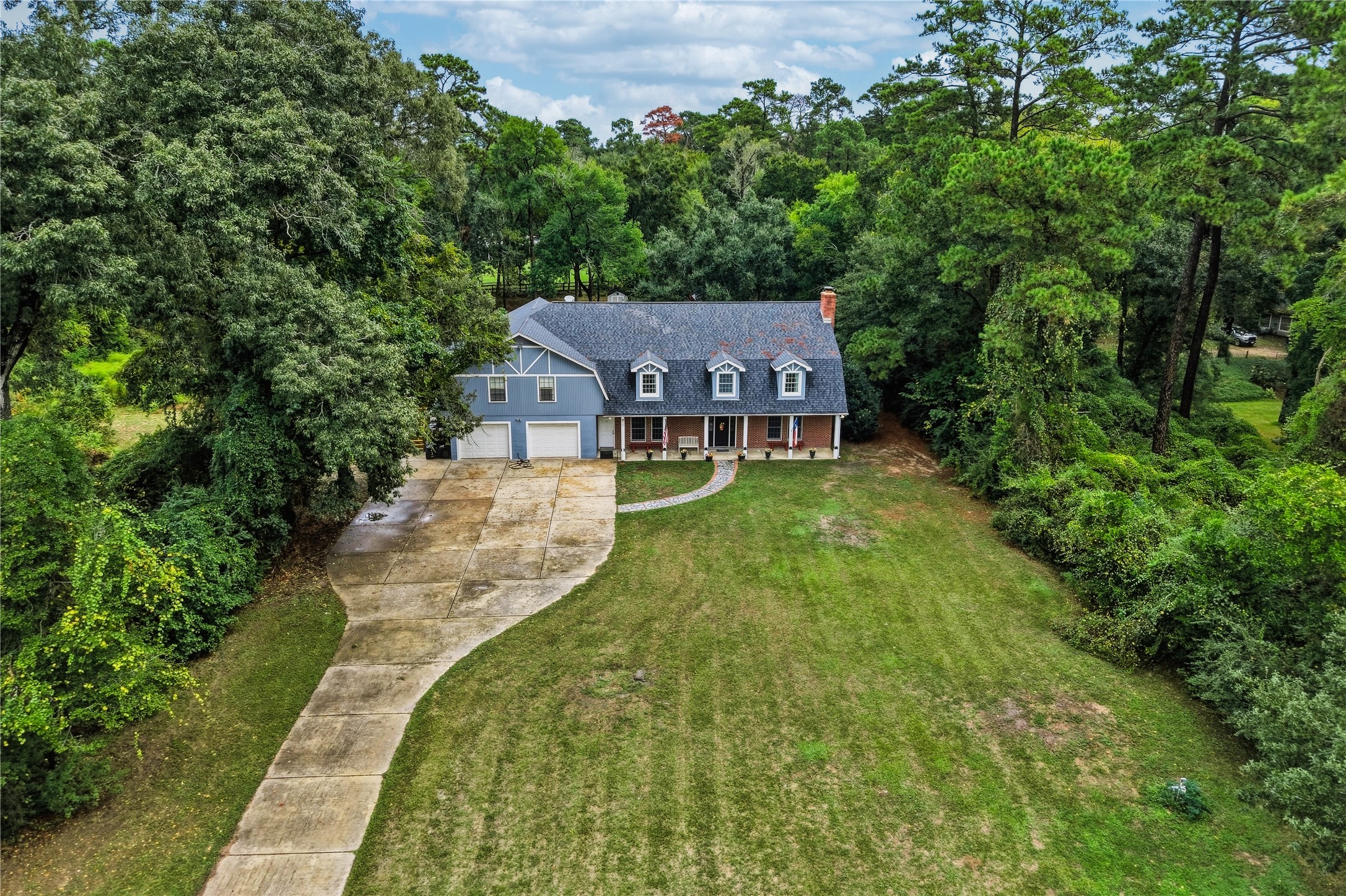 An impressive bird's-eye view of this two-acre property, highlighting the 3,400+ sq ft home with garage 1200+ sq ft apartment and a tandom 6 car garage.