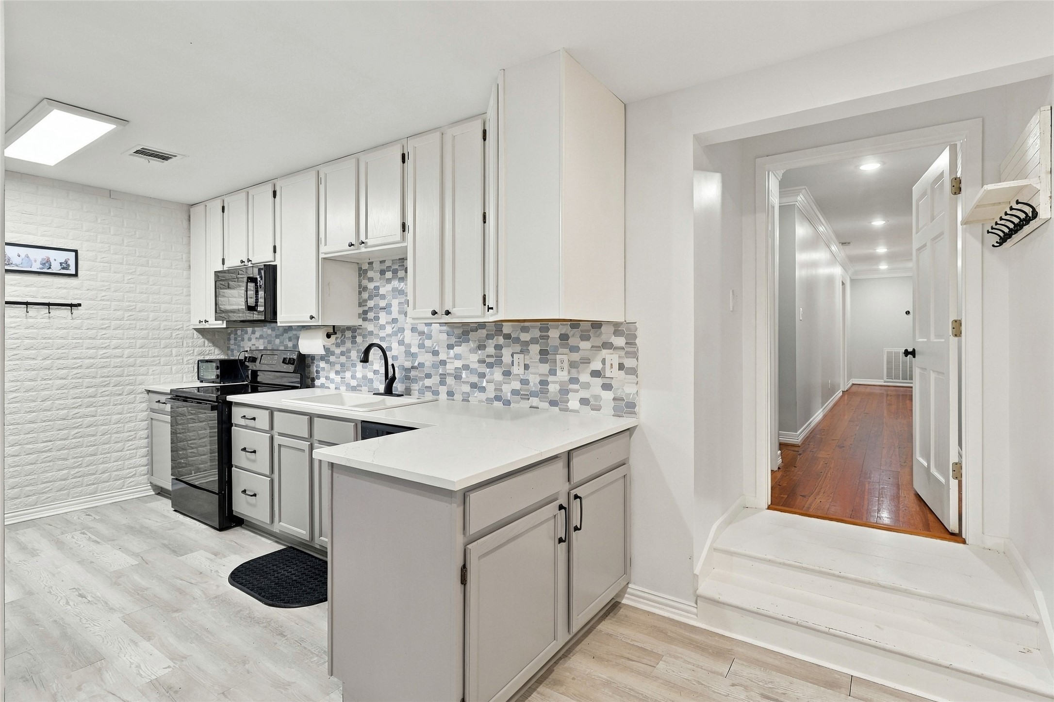 This connected garage apartment boasts an updated full kitchen, complete with attractive two-tone cabinets and a stylish backsplash.