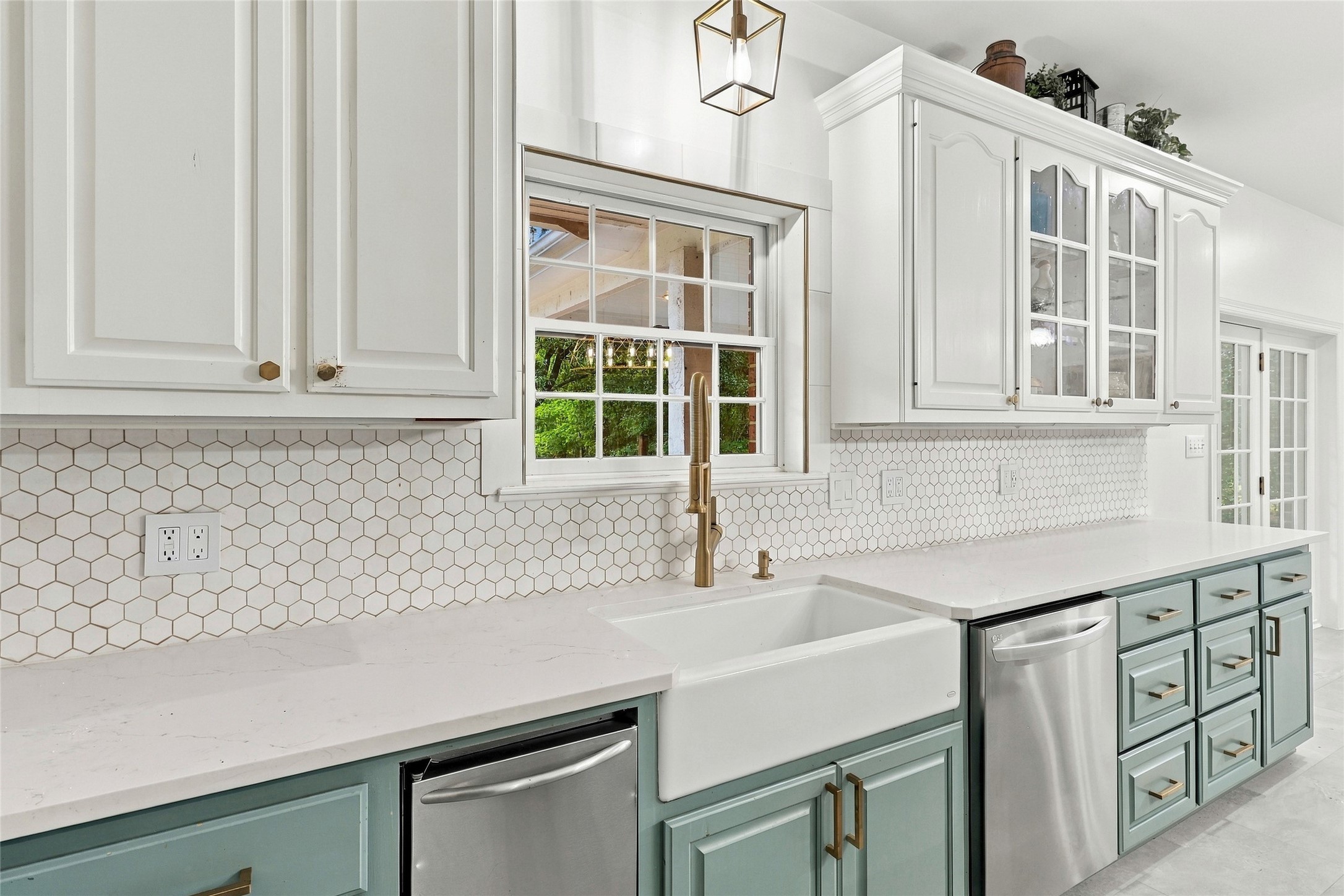 This kitchen features a deep apron-front farmhouse sink set against a beautifully coordinated, tiled backsplash.