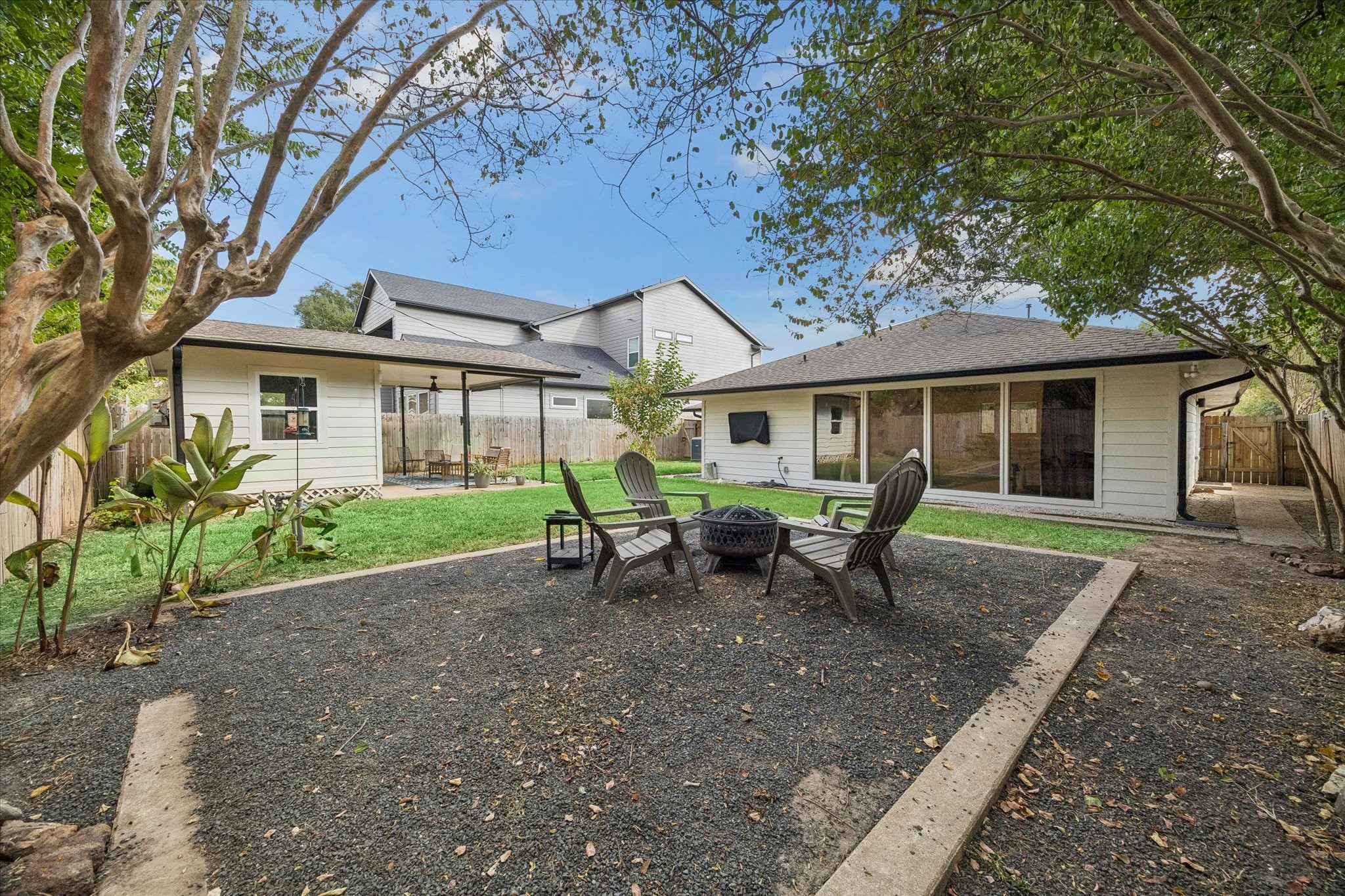 Anchored by a dedicated fire pit area beneath mature shade trees, the backyard is made for relaxed evenings, conversation and gathering outdoors.