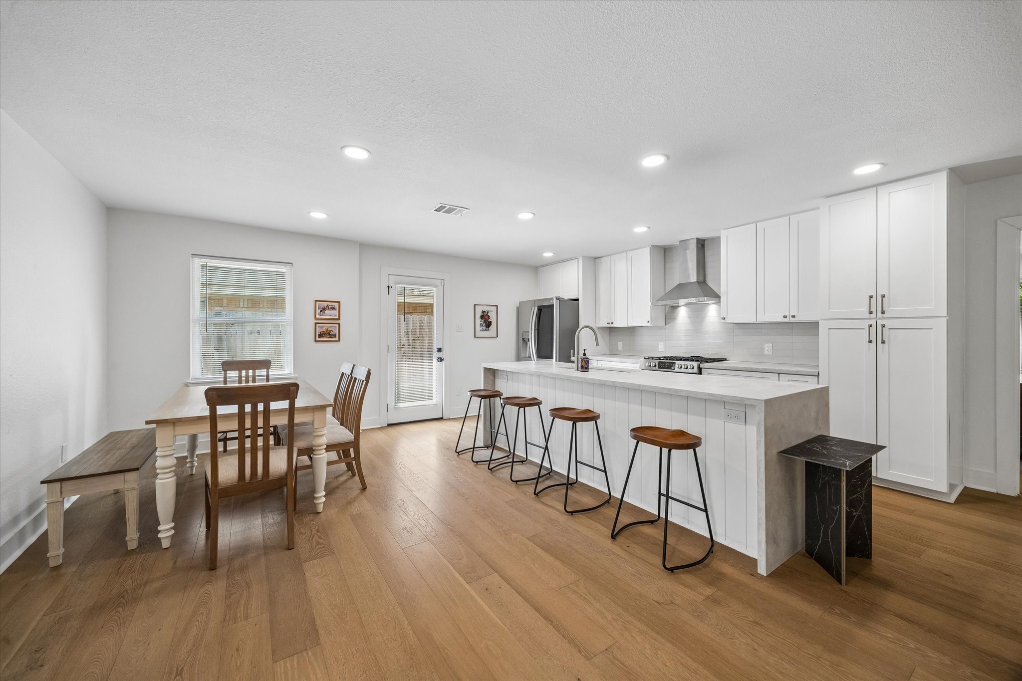 Everyday living feels effortless with the kitchen and breakfast area brought together in one open space. A wall of cabinetry provides impressive storage while a glass door offers direct access outdoors.
