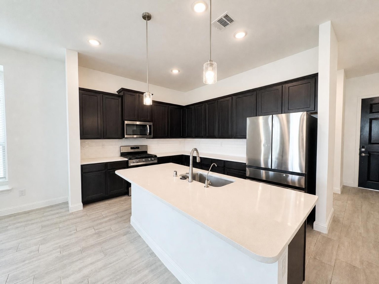 The kitchen includes 3CM quartz counters, 42" cabinets, and a large island.