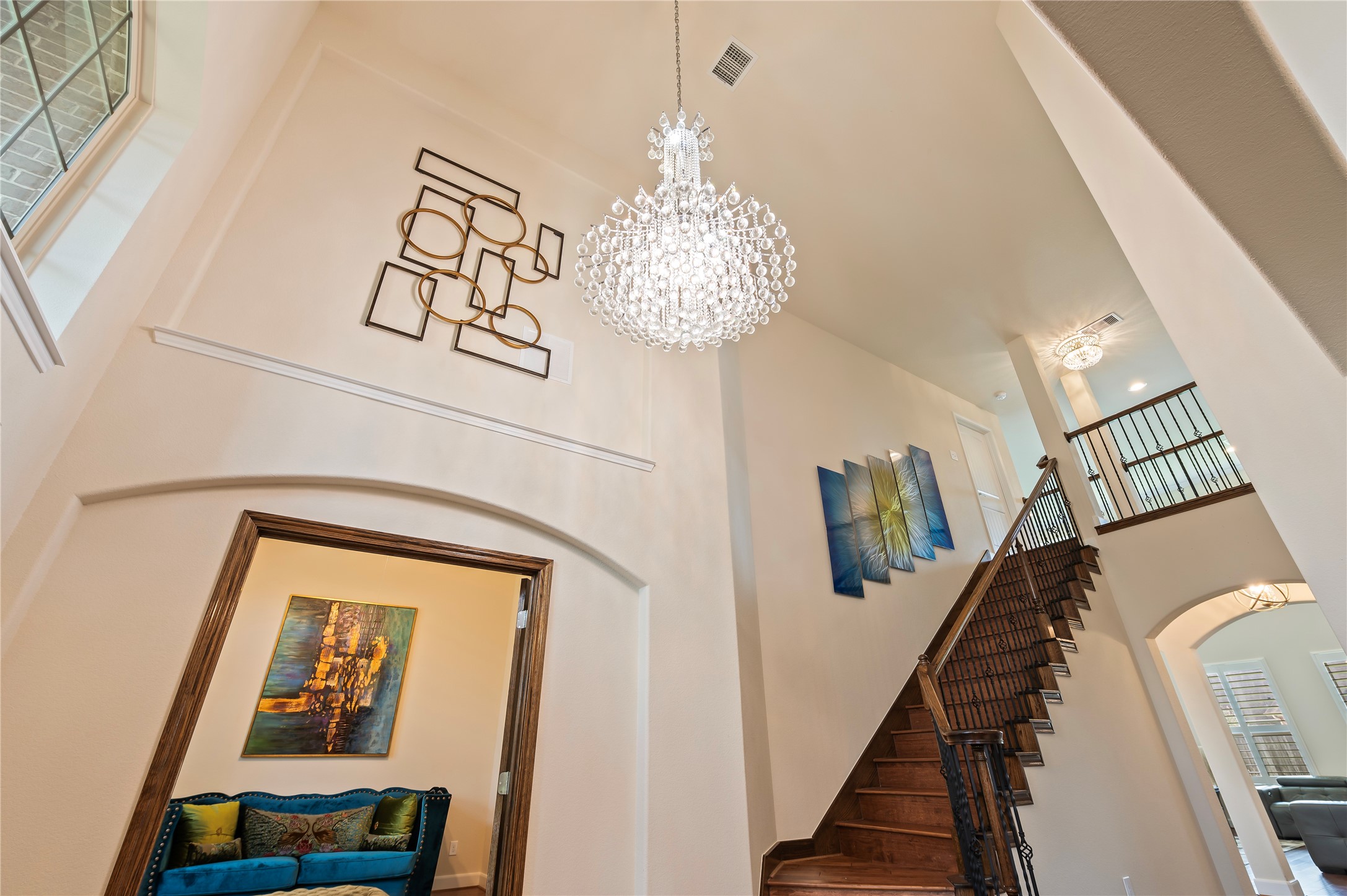 Soaring ceiling at entrance with custom chandelier and art niches,