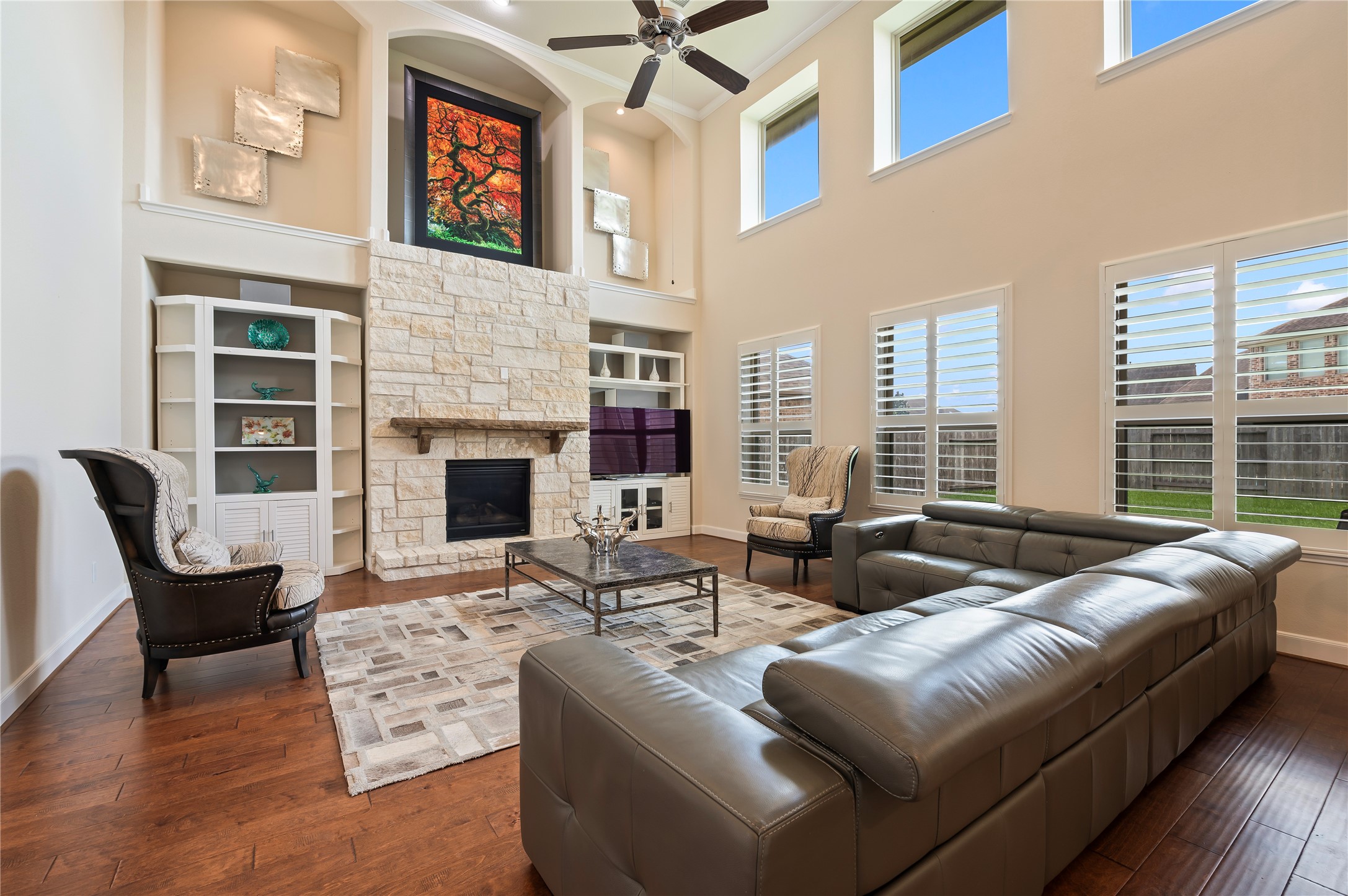 Family room features floor-to-ceiling windows, creating a light, open atmosphere throughout the home. Rich solid hardwood flooring adds timeless warmth and sophistication.