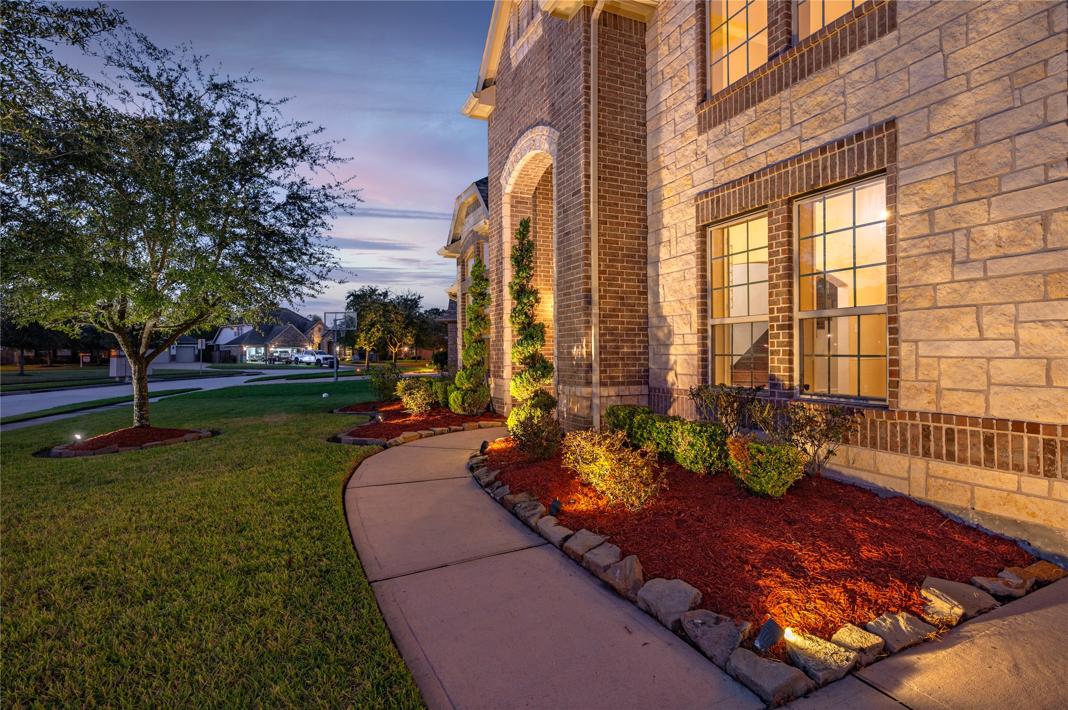Elevation B features professionally maintained lawn, extensive landscaping lighting, exterior stone accent and 2-story covered front porch.