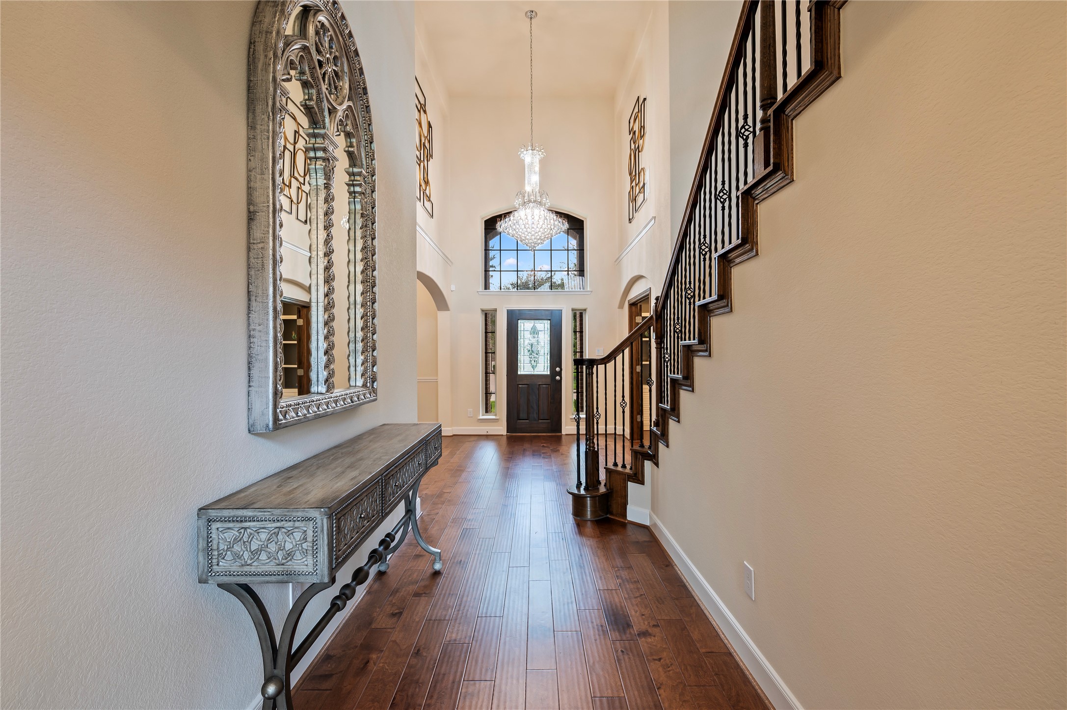 Another view of the inviting entrance with neutral paint tones and art niches above the formal dining and private office.