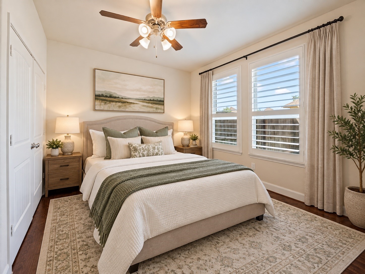 2nd bedroom downstairs with rich hardwood flooring, neutral paint tones, ceiling fan and plantation shutters. (Virtually staged)