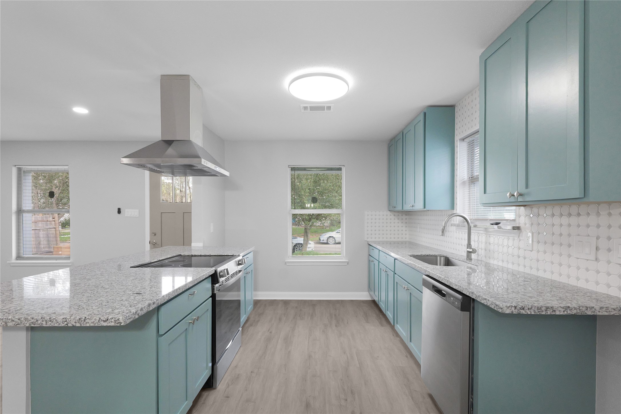 Colorful cabinetry, stainless steel appliances, and a tile backsplash give this updated kitchen its standout style.