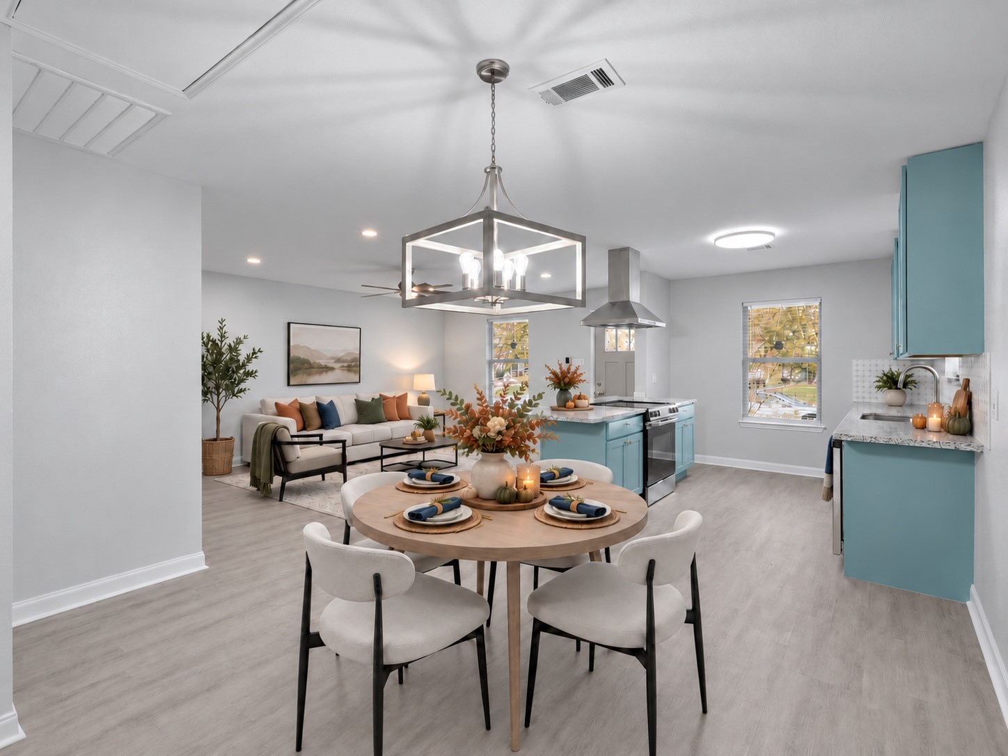 Open living, dining, and kitchen areas offer a connected space for everyday living and entertaining. Digitally staged.
