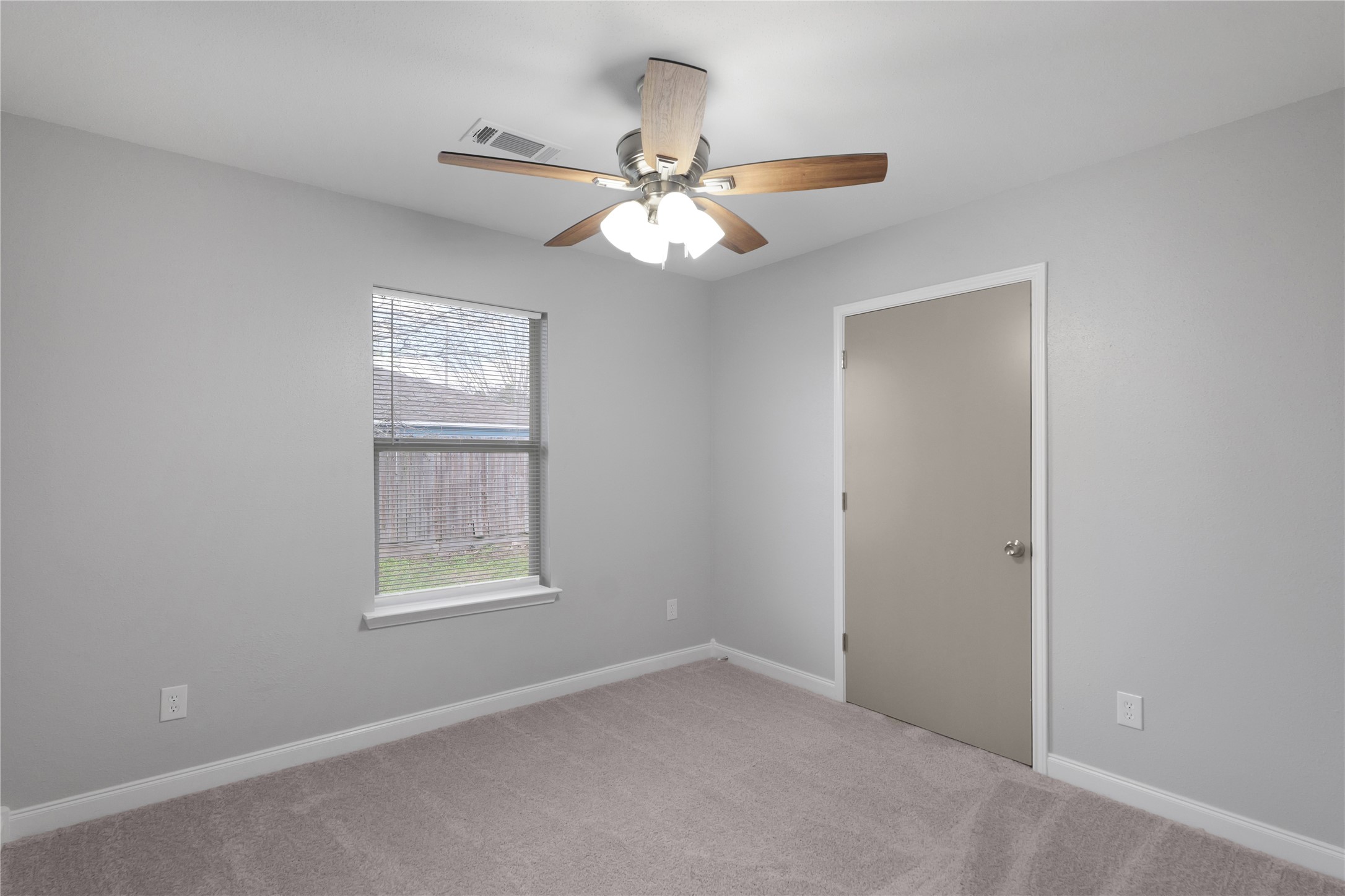 Natural light and neutral finishes provide a versatile backdrop in this secondary bedroom.