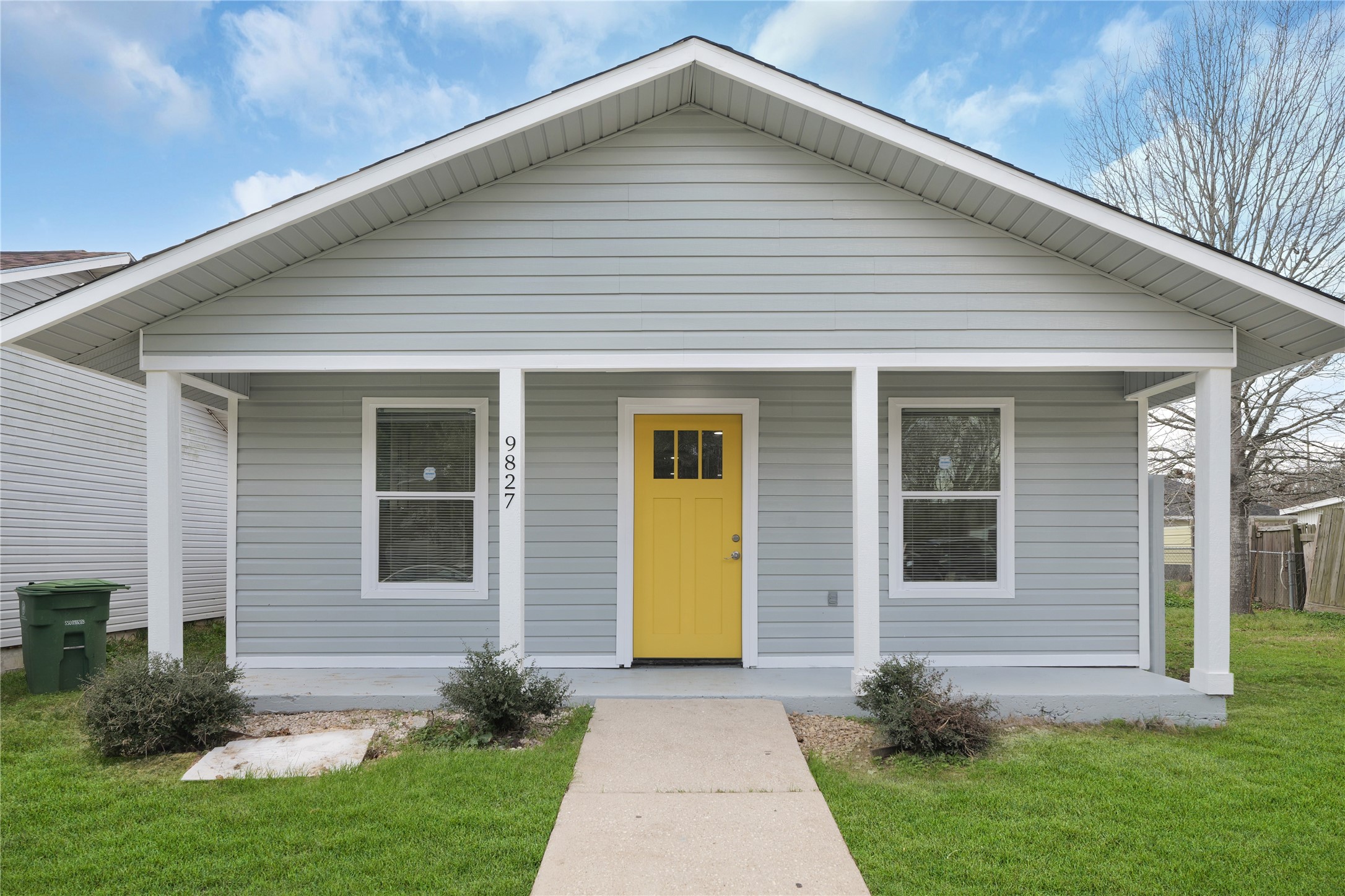 Welcome to 9827 Shive Dr! A bright yellow front door adds personality to the covered front porch.