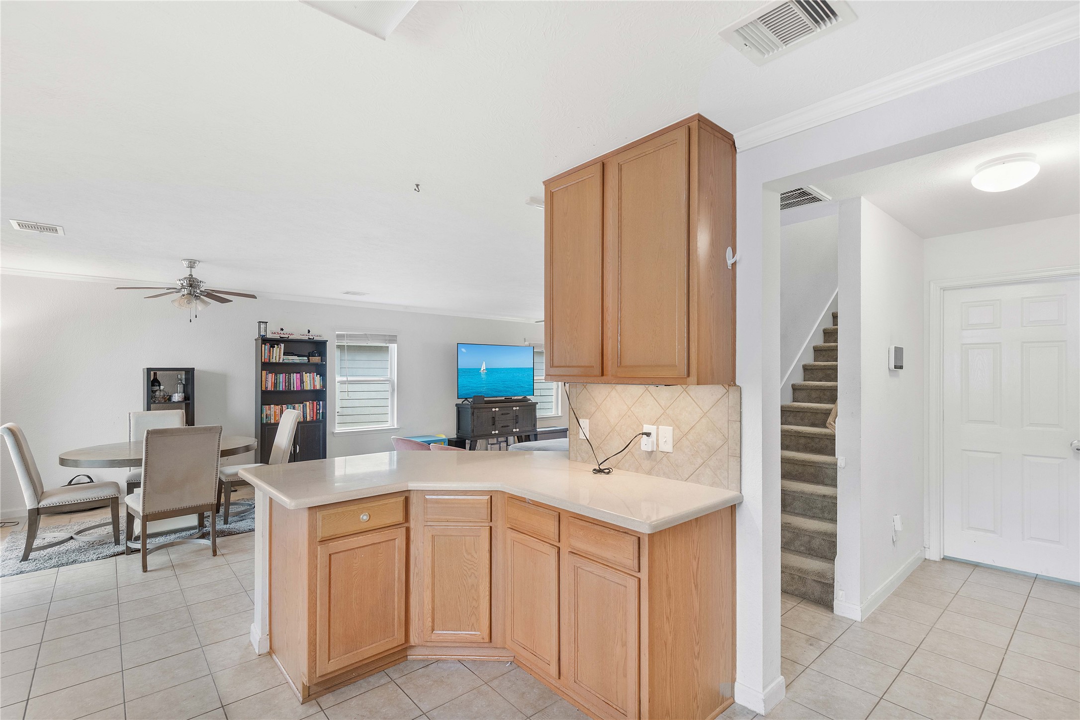 Spacious open-concept living area features a modern kitchen with ample cabinetry, flowing seamlessly into a bright dining space and cozy living room, perfect for family gatherings.