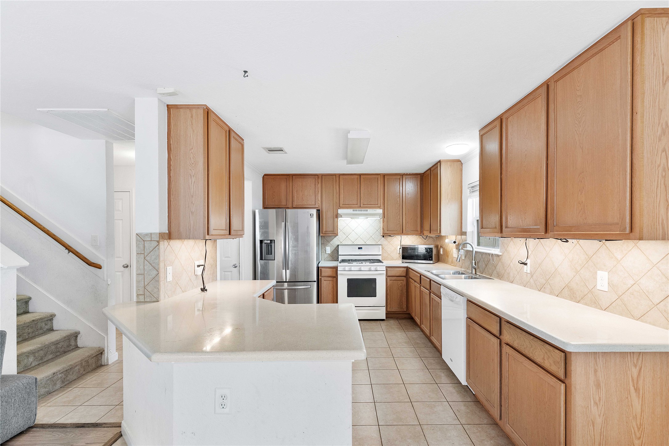 Spacious kitchen with ample wooden cabinetry, sleek countertops, and modern stainless steel appliances, offering a perfect blend of style and functionality.