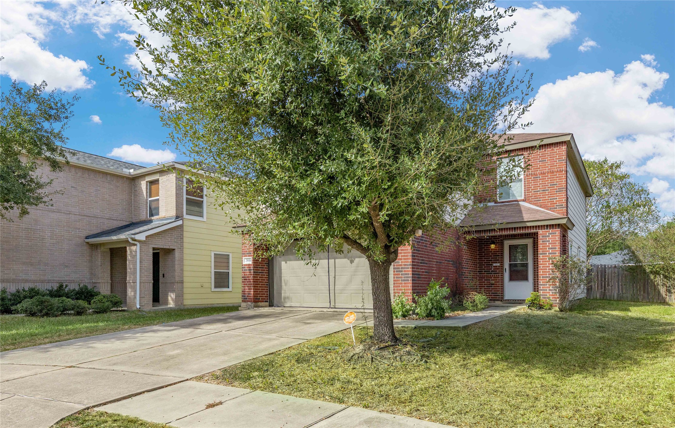 Charming two-story brick home with a front-facing garage and a well-maintained lawn, nestled in a peaceful neighborhood.