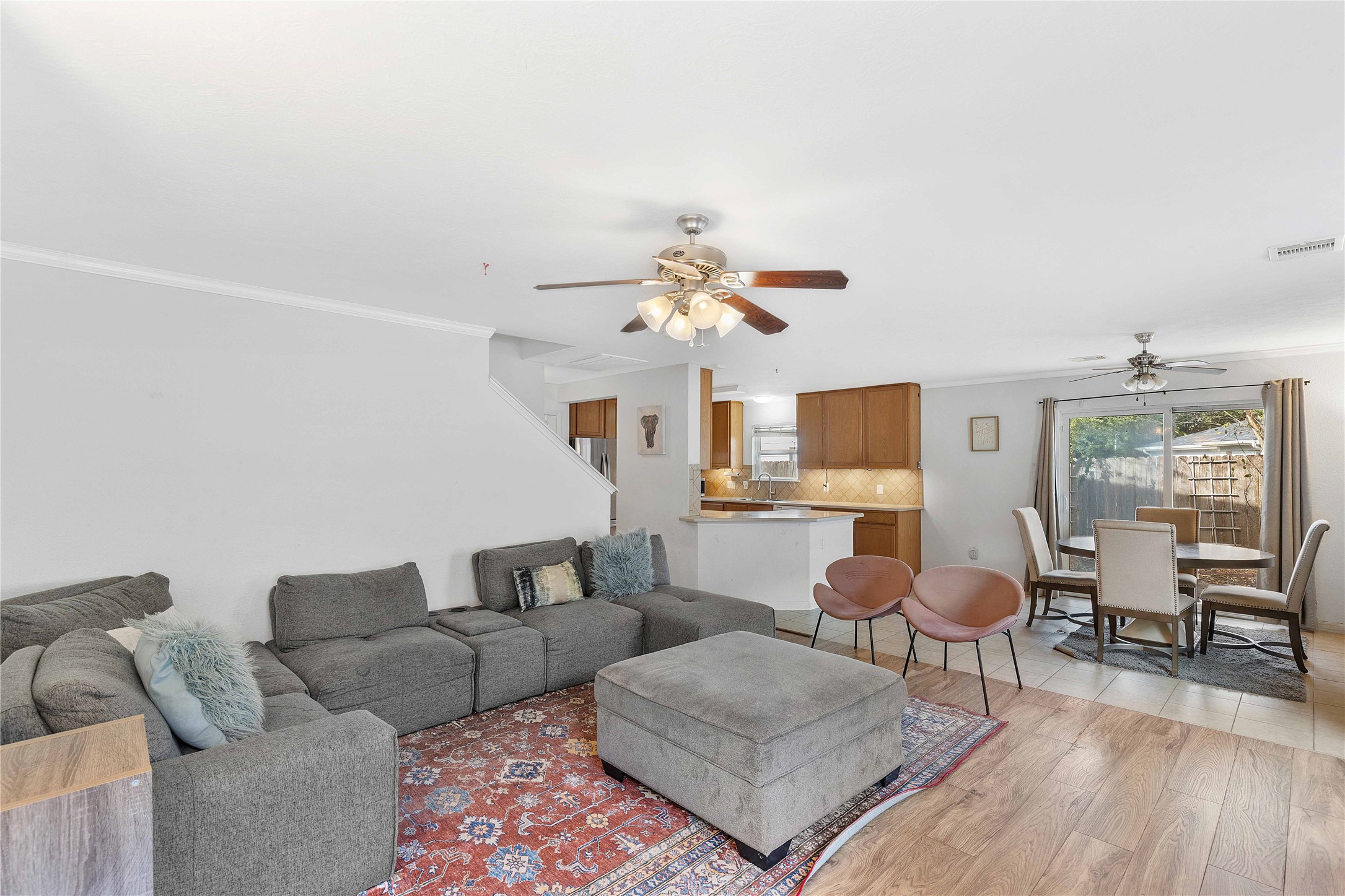 Spacious open-concept living area featuring a cozy sectional sofa, stylish dining space, and a modern kitchen with ample cabinetry, perfect for entertaining and family gatherings.