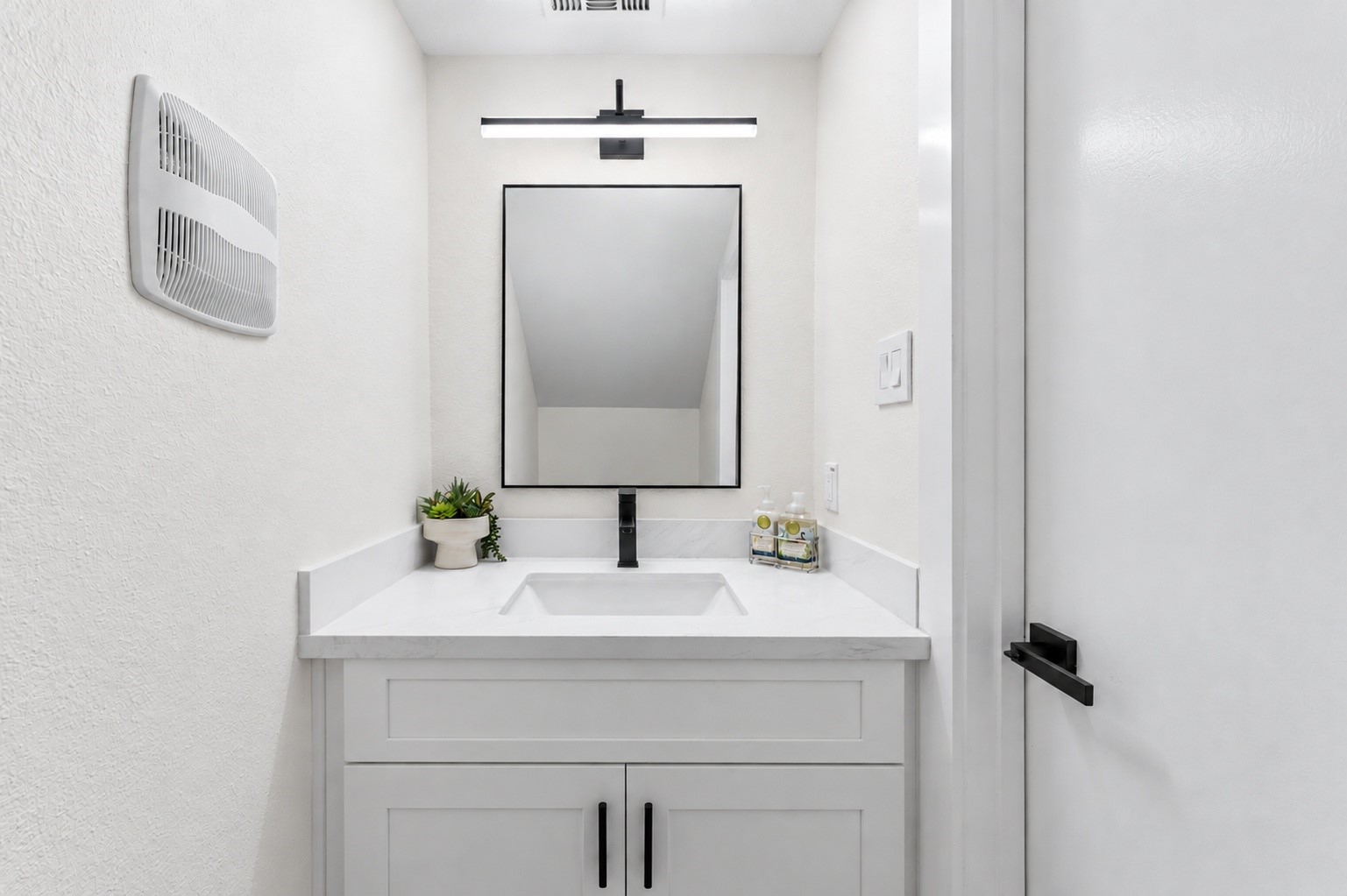 The half bathroom has been updated with new quartz countertops, new cabinets, and a new toilet!