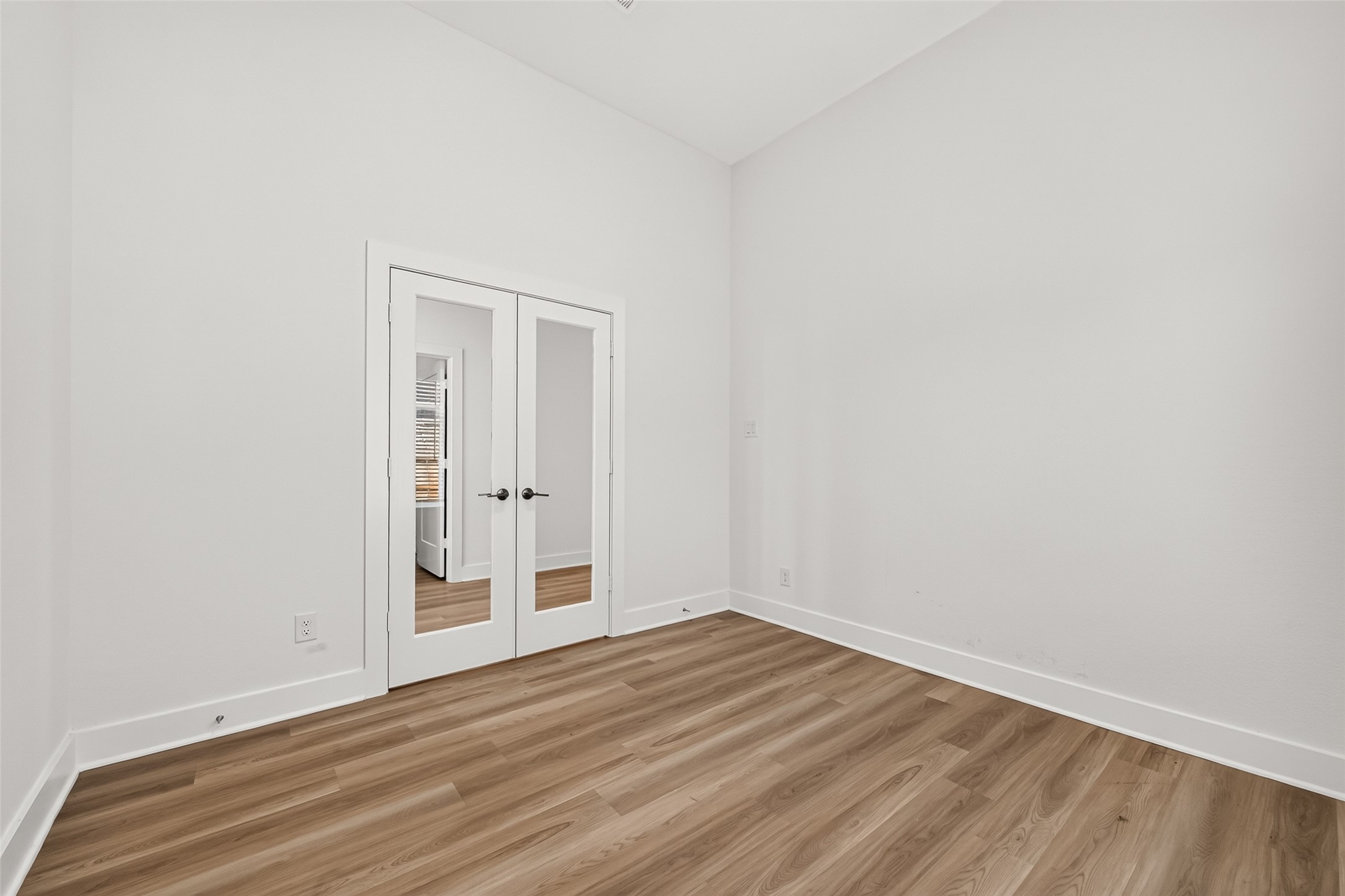 Flex room with French glass doors, vaulted ceiling, and wood-look flooring. Works well as a home office or study. Flex room with French glass doors, vaulted ceiling, and wood-look flooring. Works well as a home office or study.