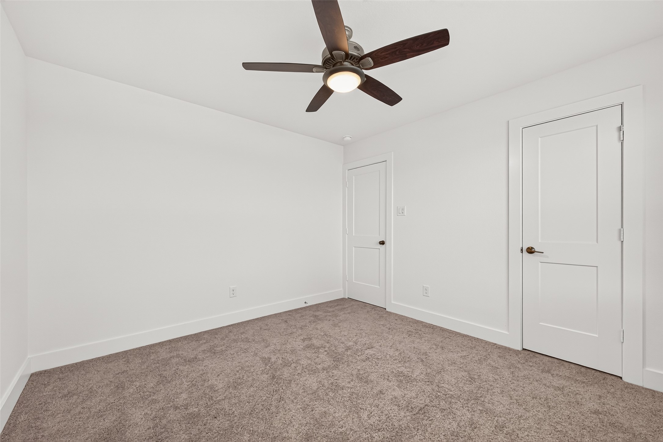 Upstairs bedroom with carpet, ceiling fan, and closet.