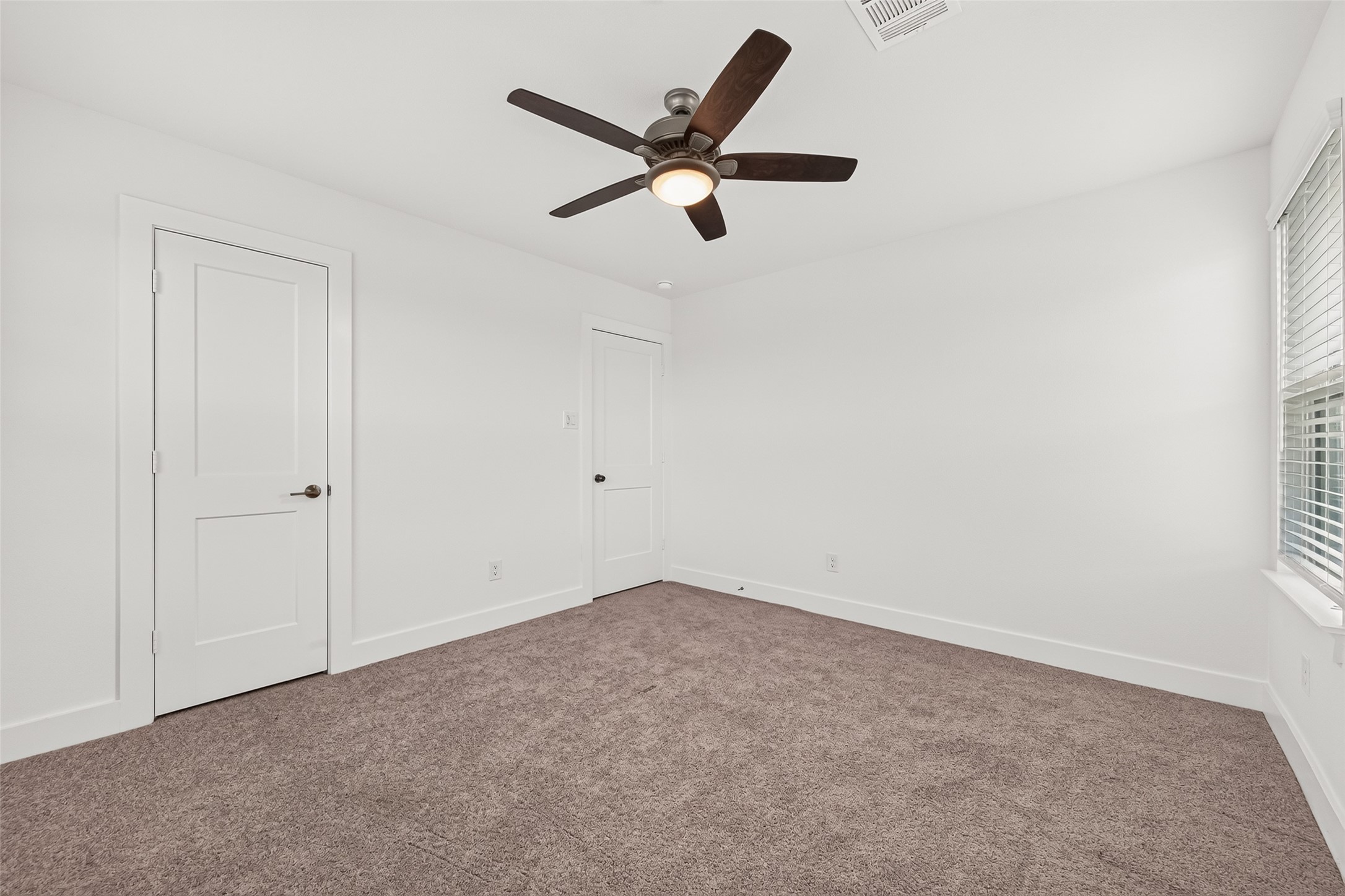 Upstairs bedroom with carpet, ceiling fan, and closet.