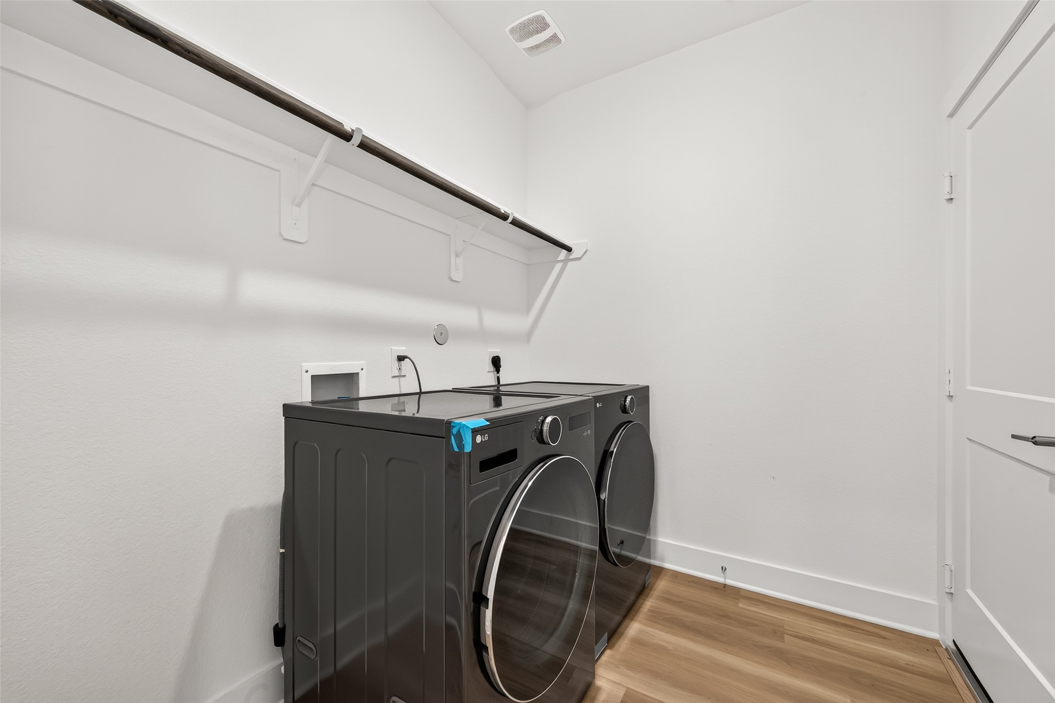 Utility room with shelving, hanging rod, and space. Washer and dryer included.