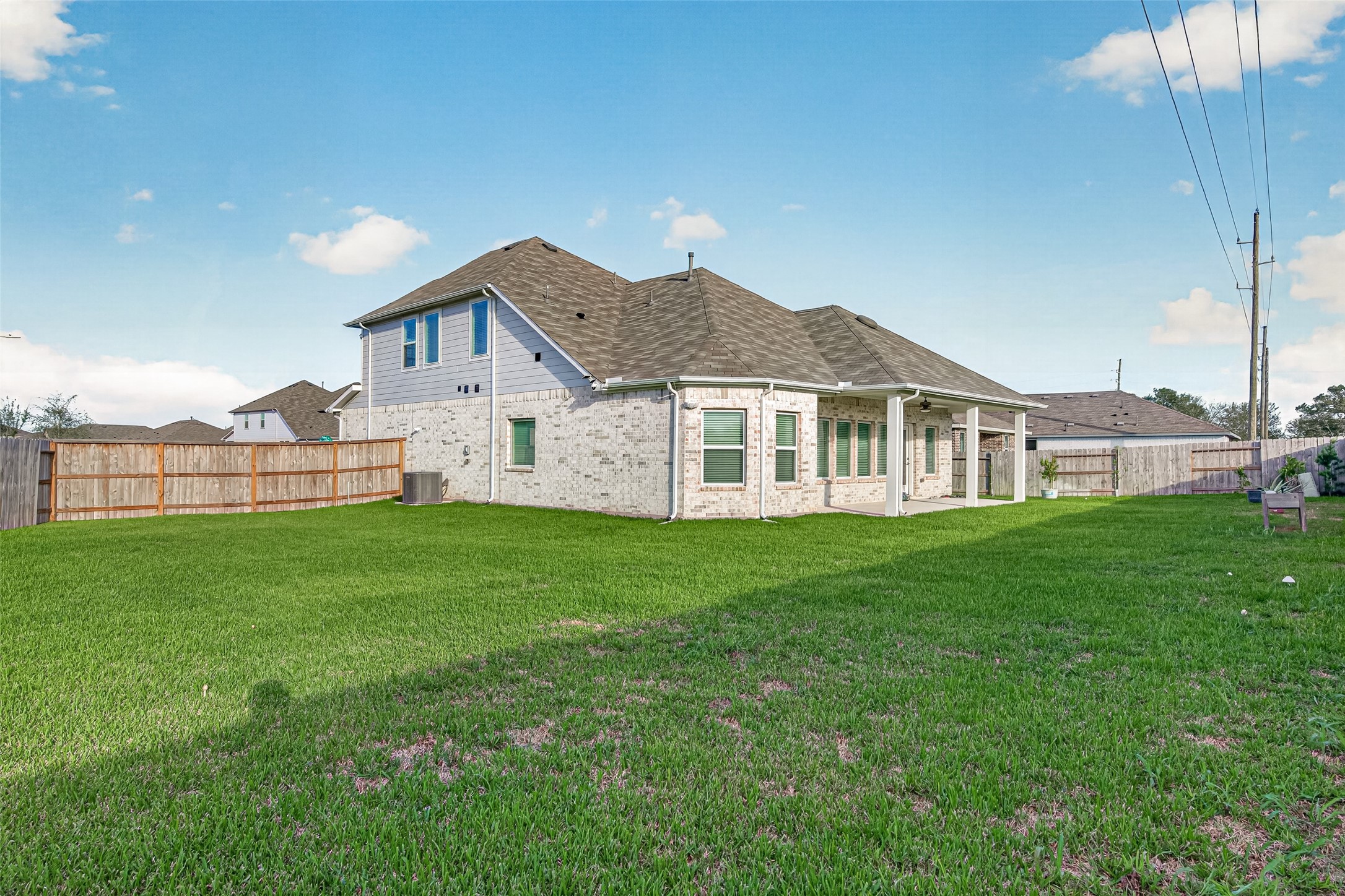 Large fenced backyard with open lawn.