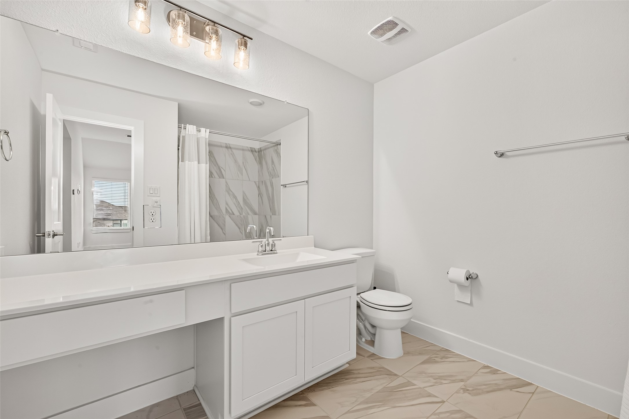 Secondary bathroom with extended vanity, storage drawers, and tub/shower combination.