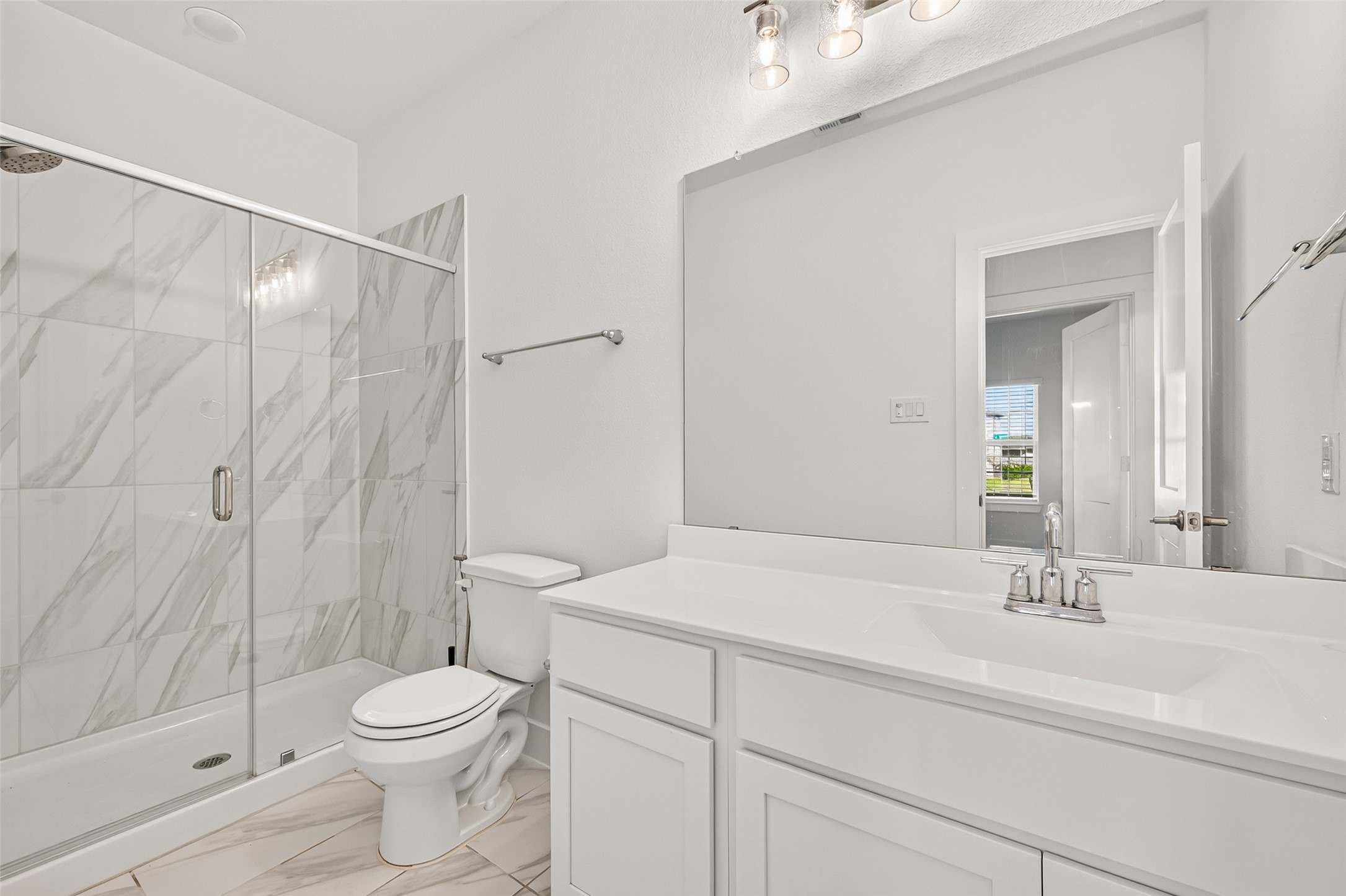 Full bathroom with glass-enclosed shower, marble-look tile, and single vanity.
