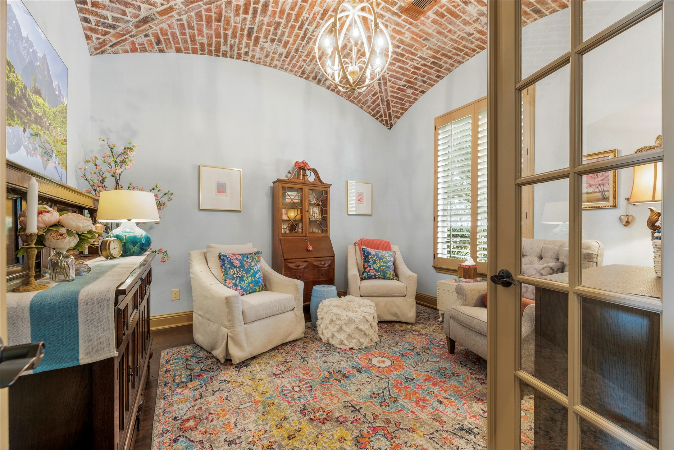 Sitting room or office featuring a painted brick accent ceiling and large windows that fill the space with natural light.