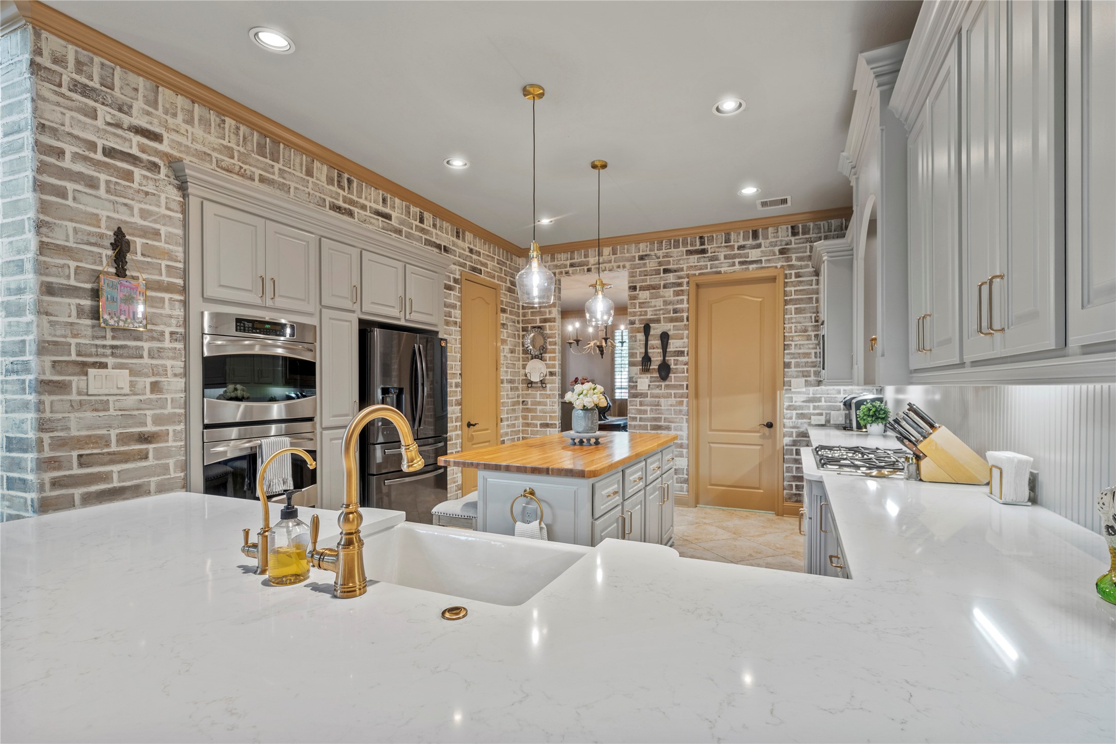Another angle of the kitchen, showcasing the generous counter space, painted brick walls, and ample storage.