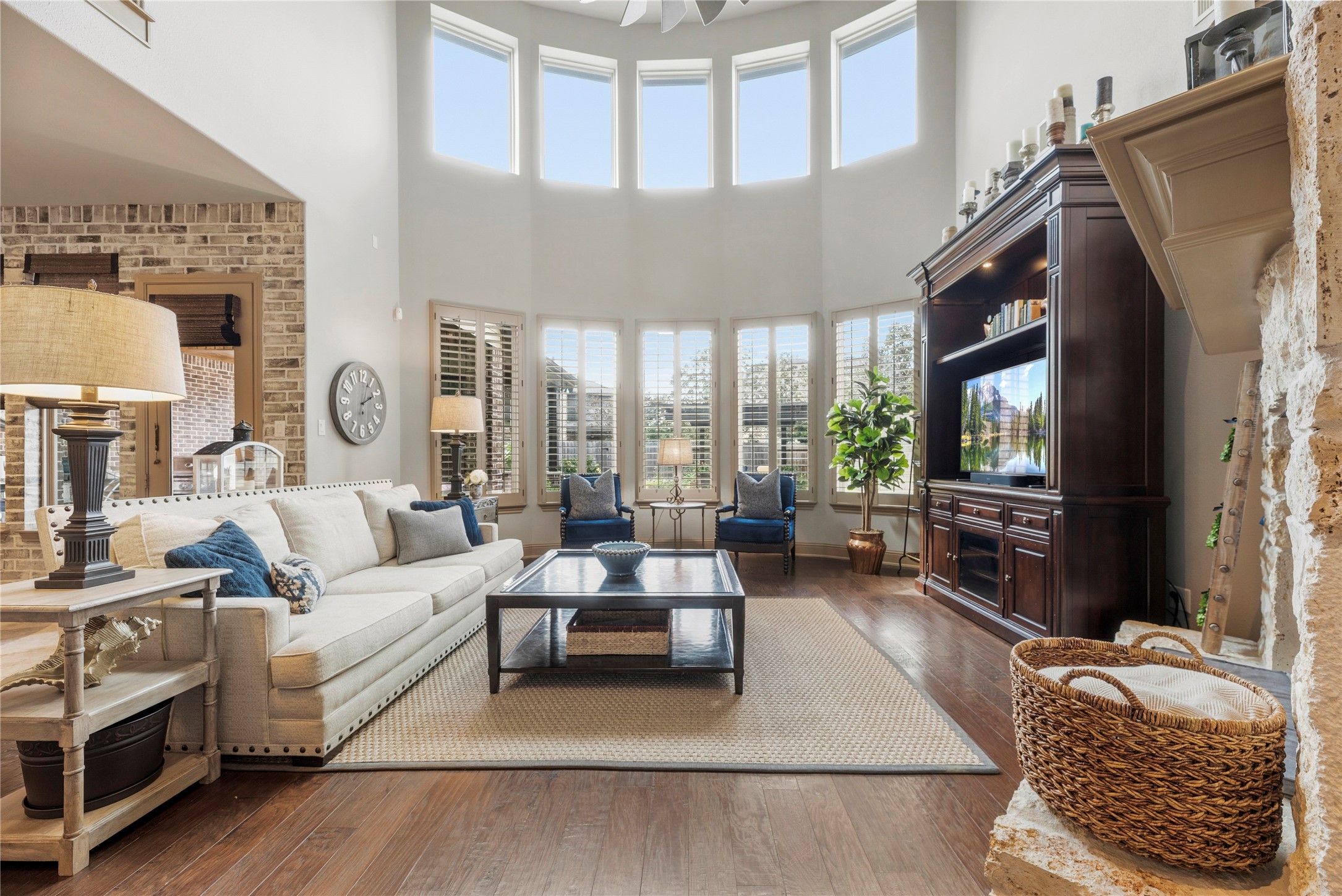 Stunning living room featuring soaring ceilings, expansive windows, and a beautiful fireplace.