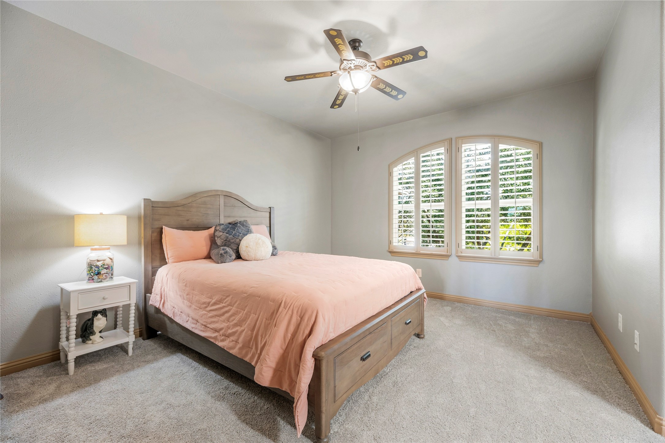 Upstairs bedroom featuring a jack and jill bath and windows overlooking the front outdoors.