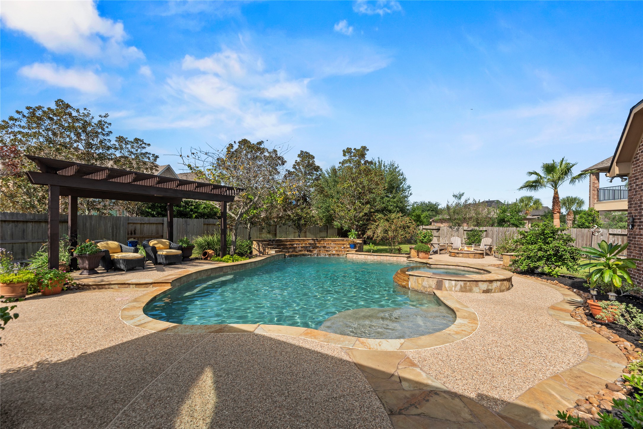 Beautiful backyard oasis featuring a sparkling swimming pool and spacious patio area for relaxing or entertaining.