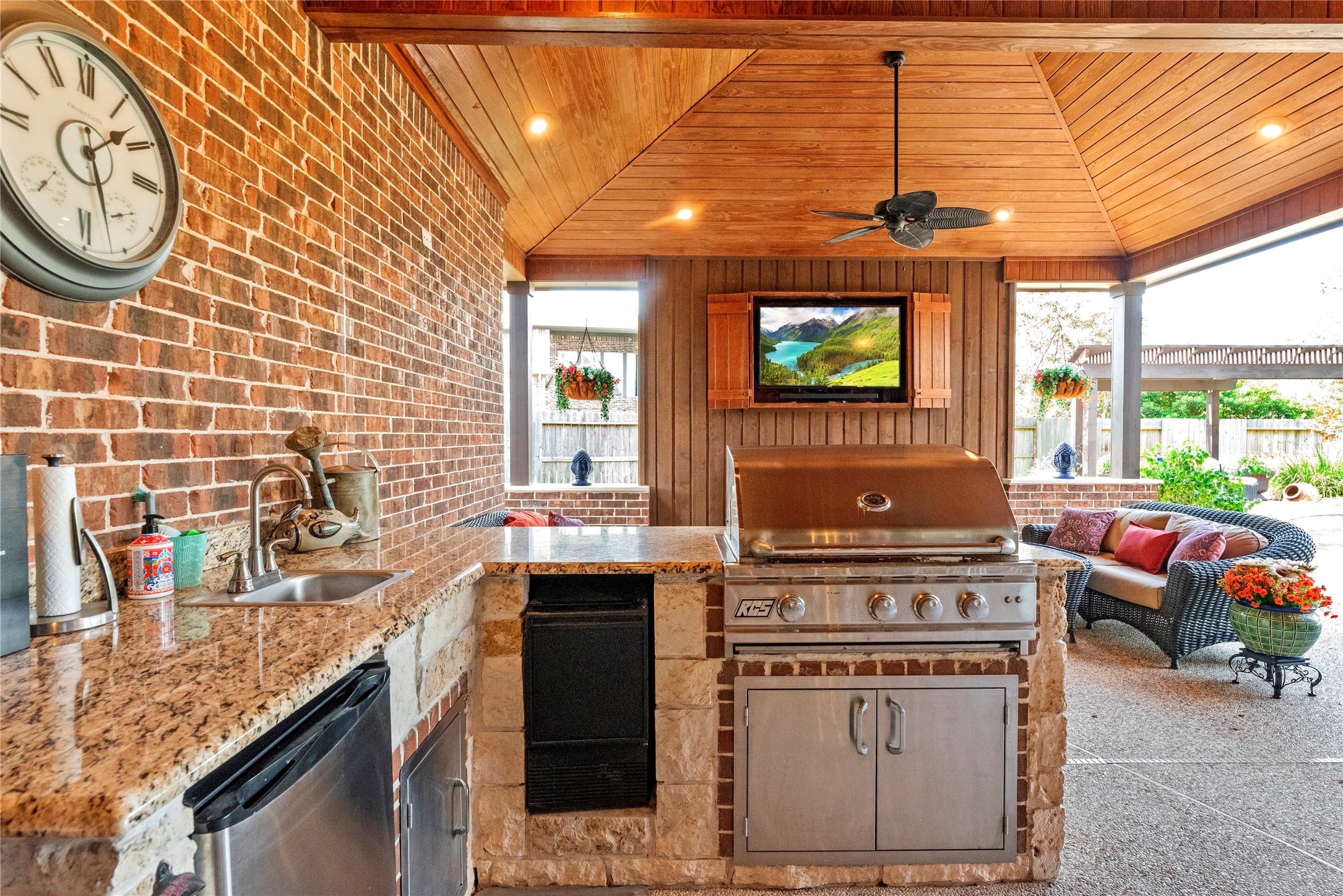 Outdoor kitchen and bar area with brick accents, perfect for hosting gatherings and enjoying time outdoors.