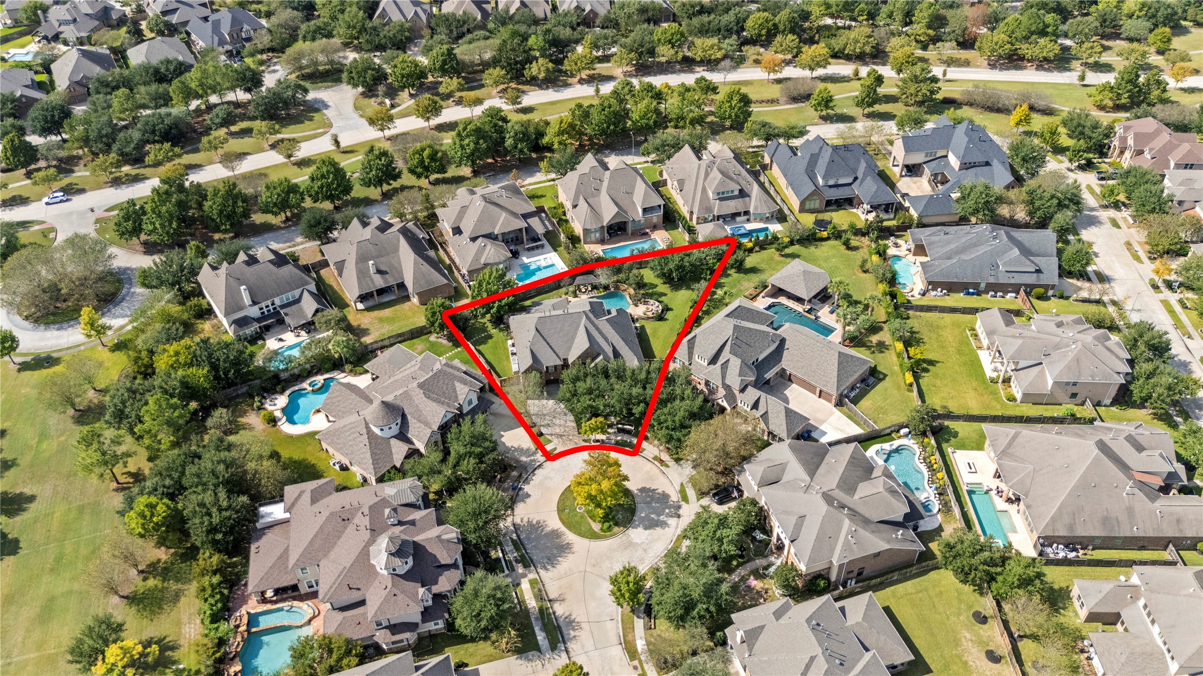 Aerial view showcasing the homes location within a beautiful neighborhood surrounded by mature trees.