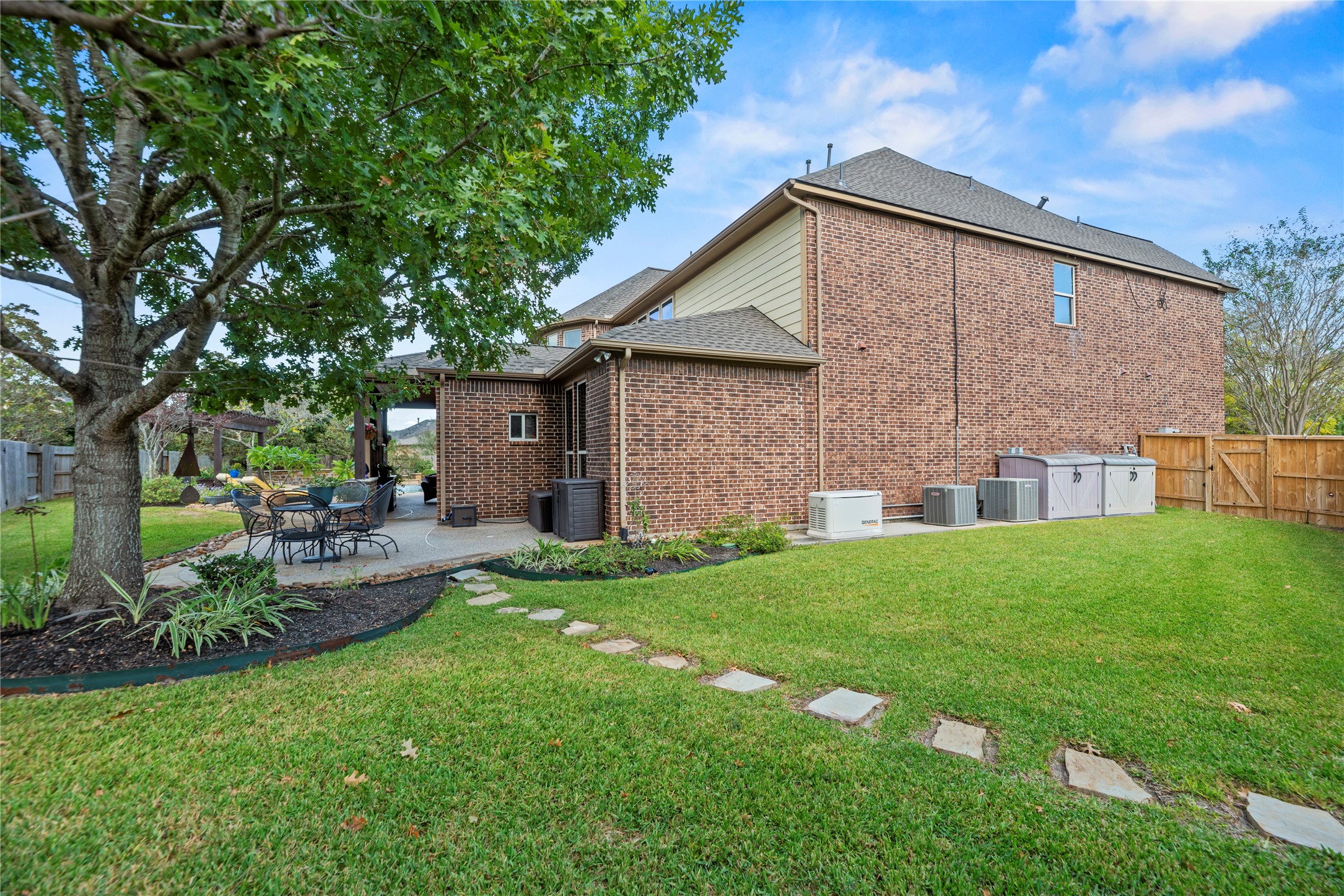 Another view of the backyard, showcasing the spacious lawn and mature trees.