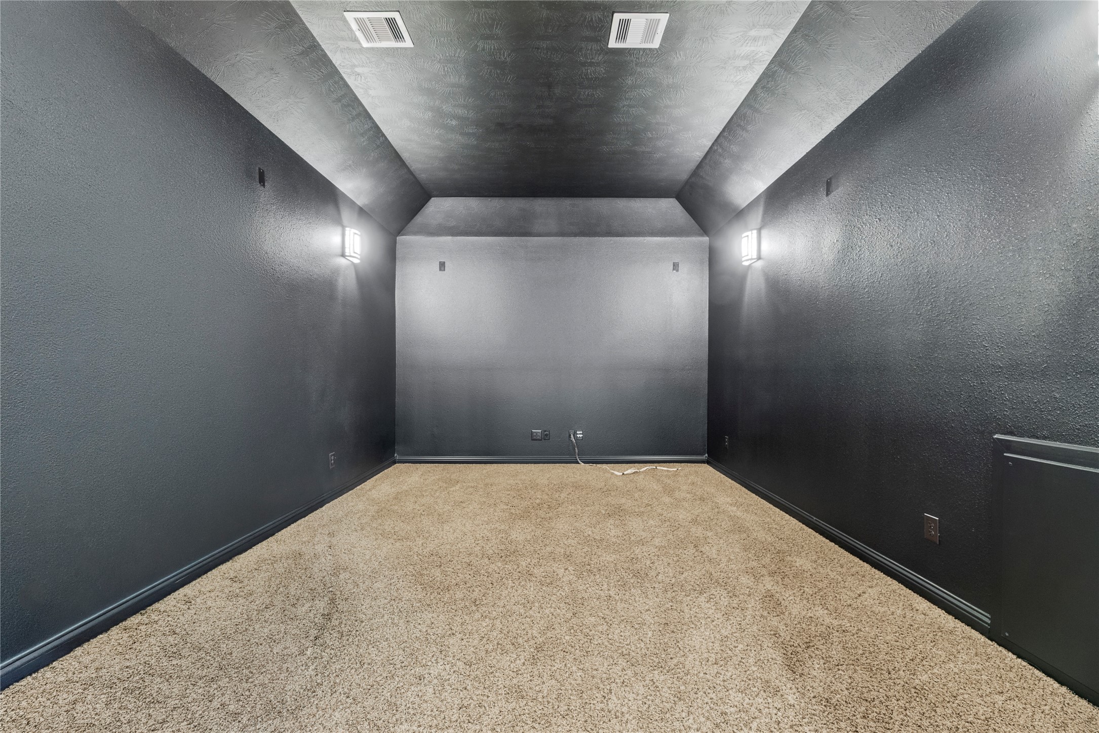 Dedicated media room with dark walls offering the perfect setting for movie nights and entertainment.
