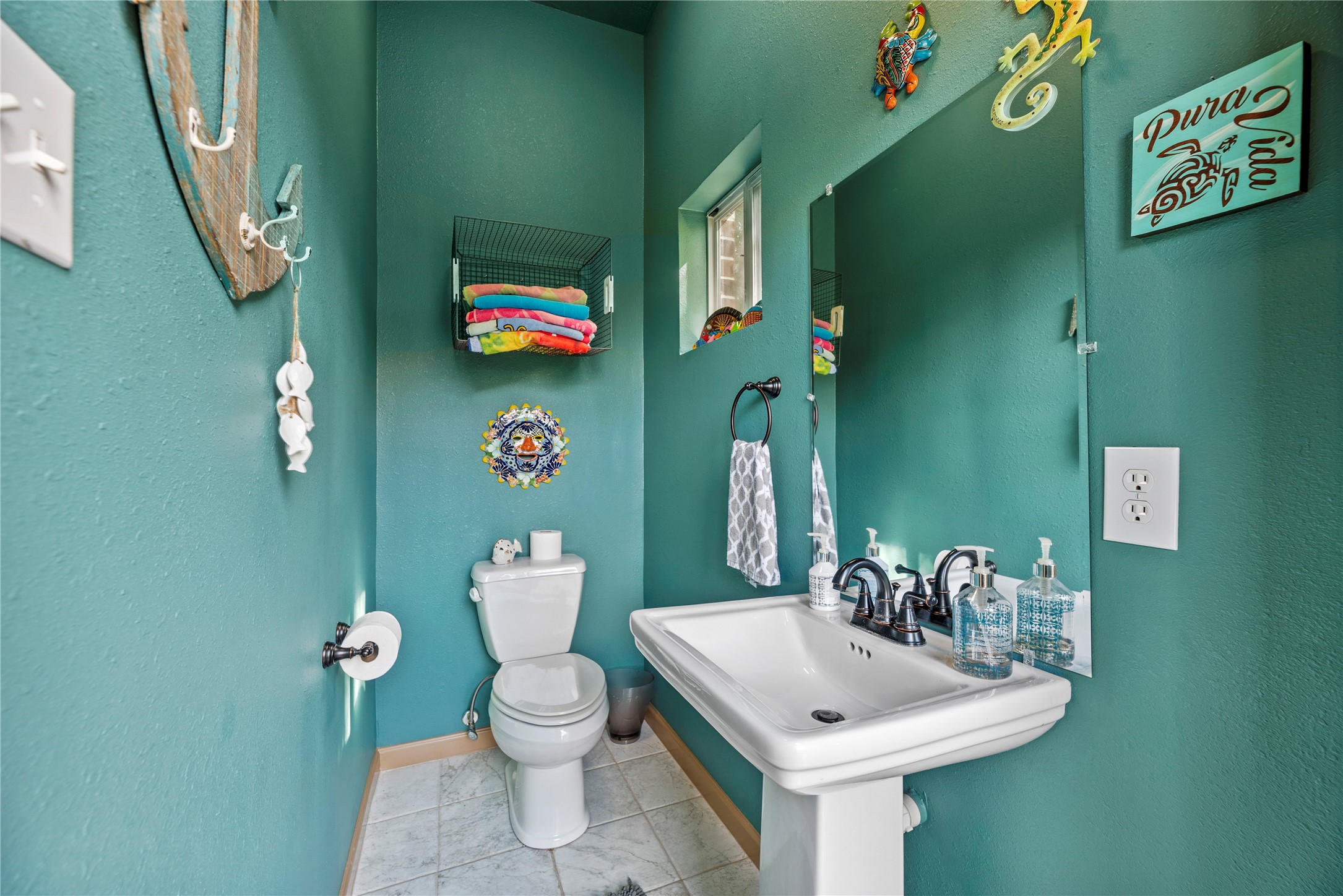 Convenient pool bathroom featuring rich green walls, a pedestal sink, and easy access for guests to enjoy the outdoor pool area.