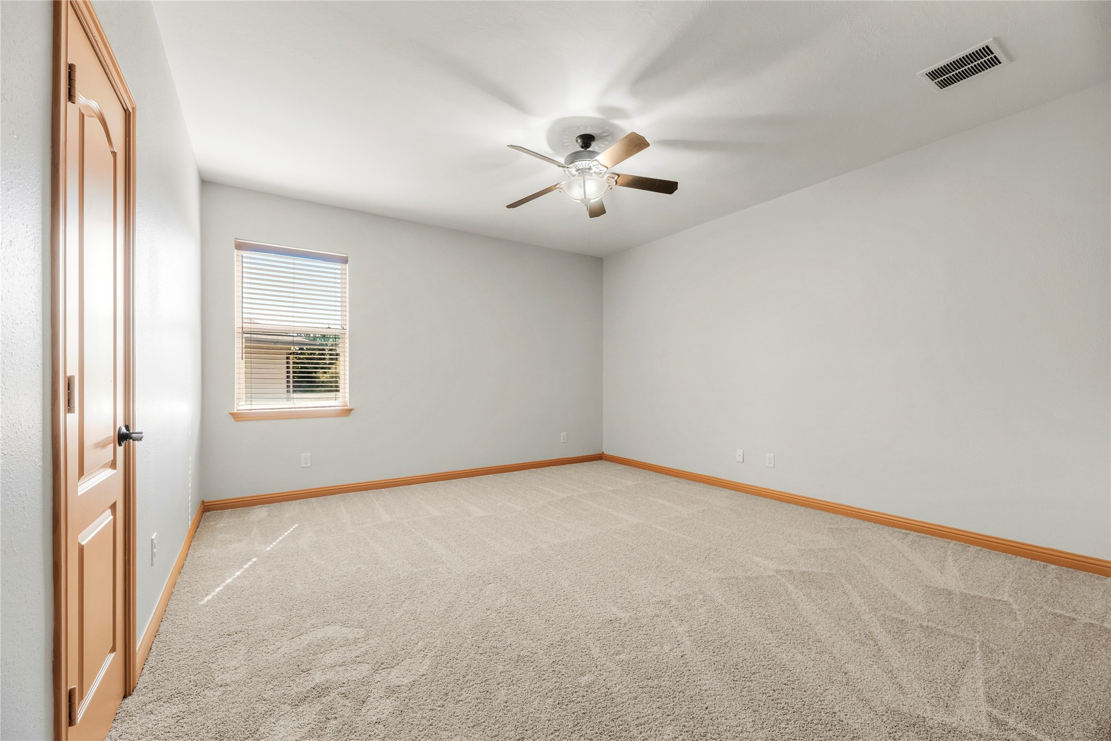 Spacious bedroom featuring a ceiling fan and a versatile layout.