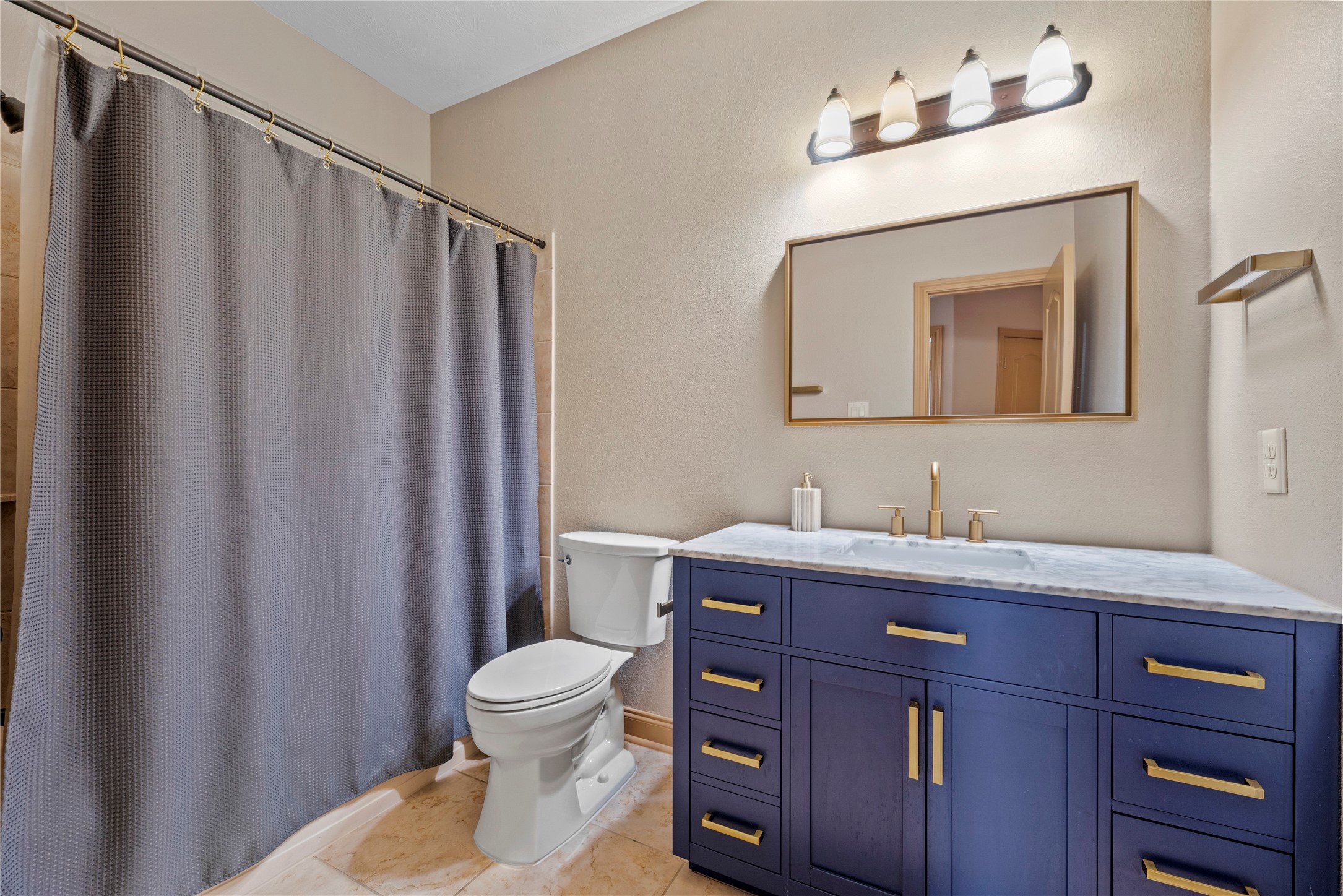 Bathroom number 4, featuring a stylish blue vanity, and shower and tub combination.