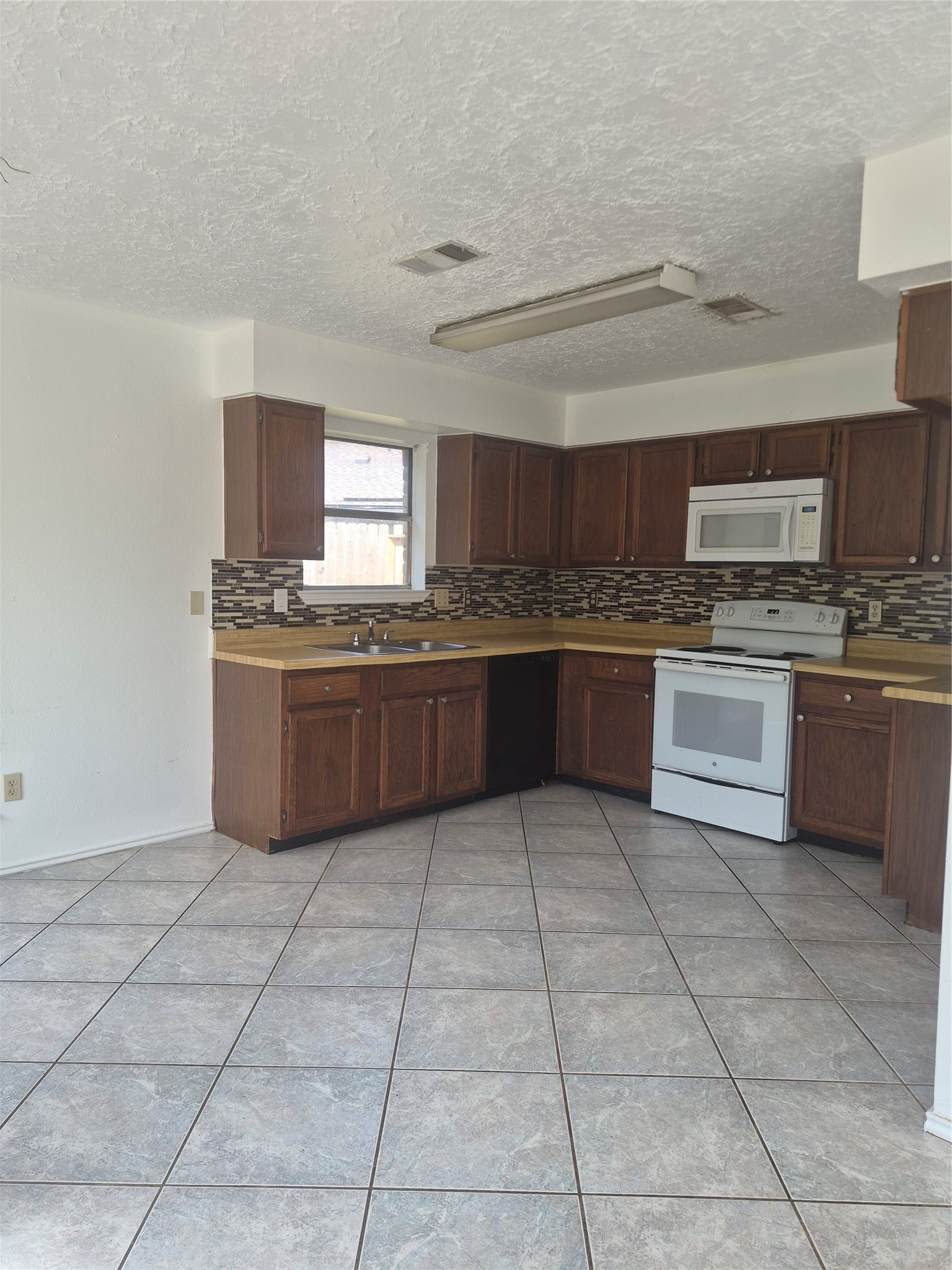 Dark wood cabinets, modern tile backsplash, and ample counter space.