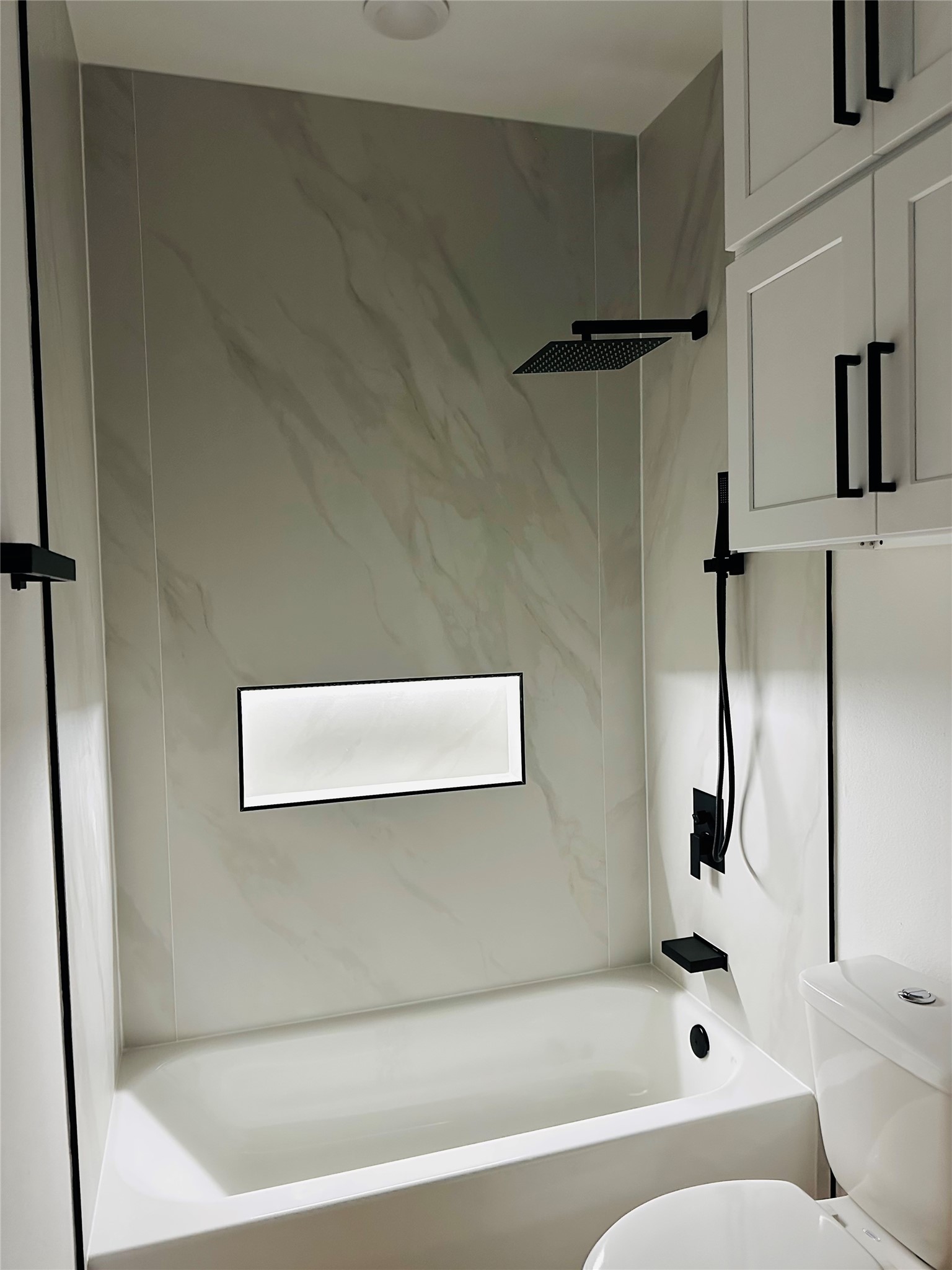 Illuminated extra large soap niche surrounded by 4ft x 8ft slabs of high end porcelain tile.