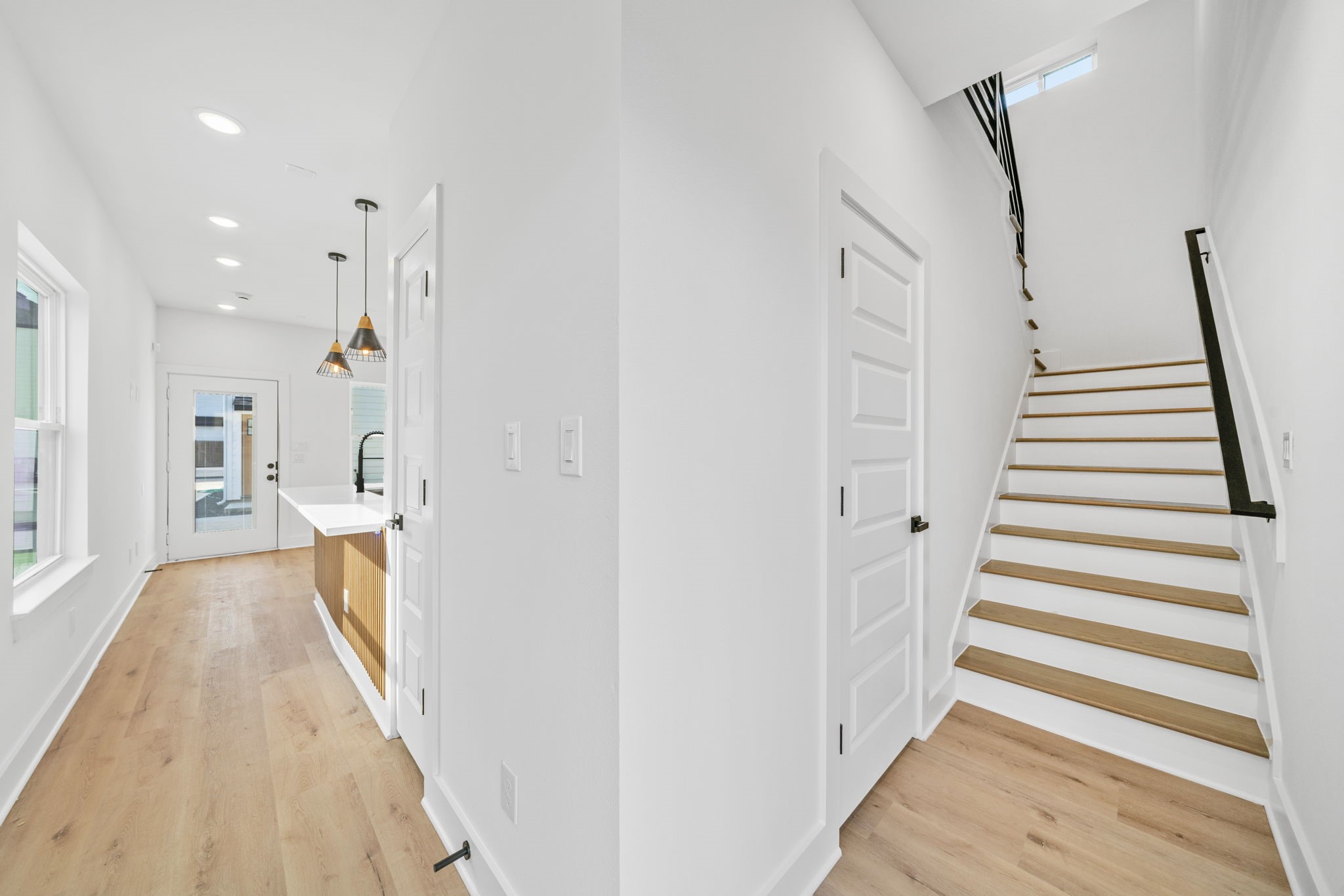 Unit C hallway leading to the 1st floor half bath and stairs to the 2nd floor