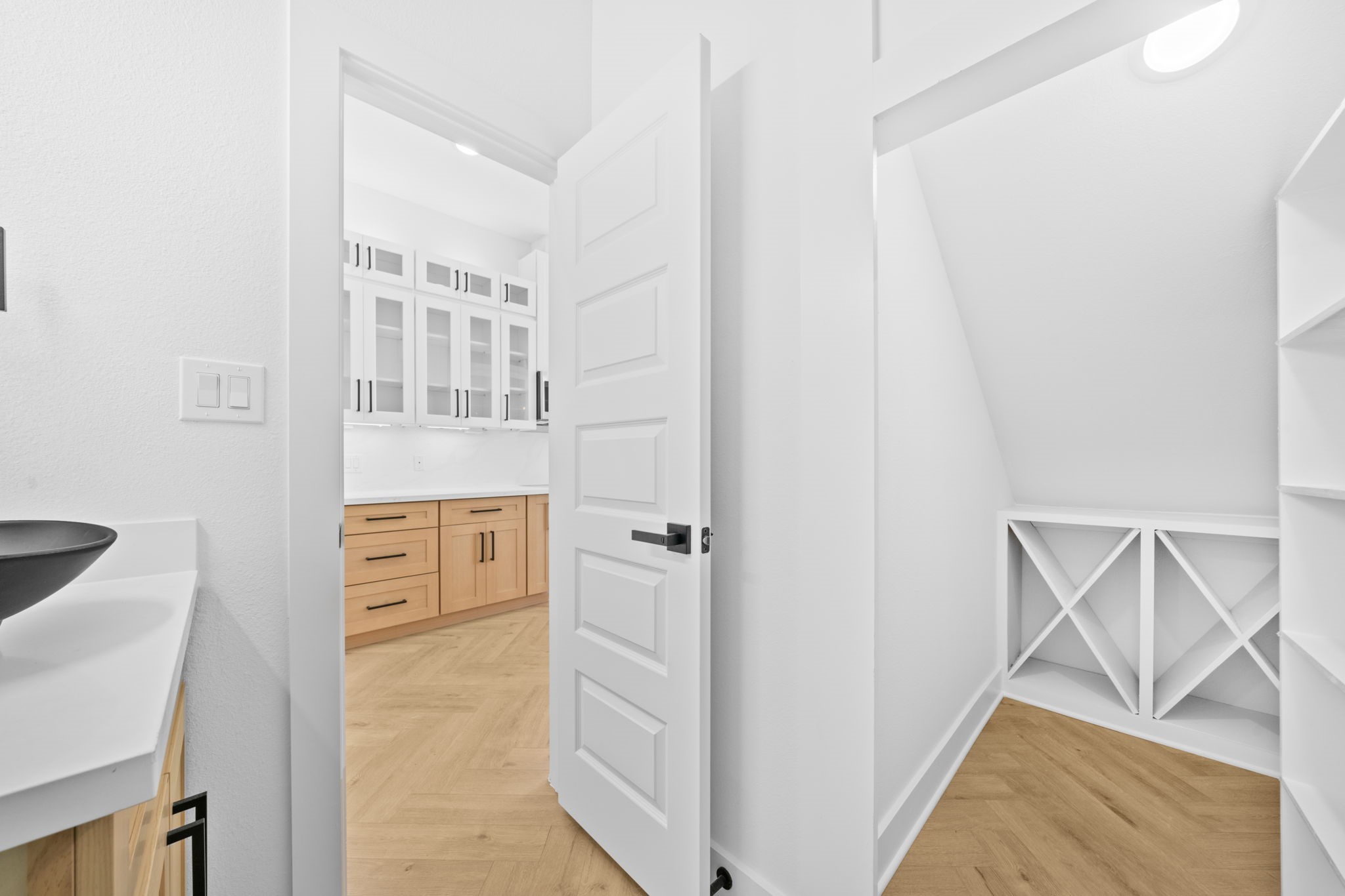 Hidden undstair closet with built in wine and liquor cabinet behind custom 5 row shelf door