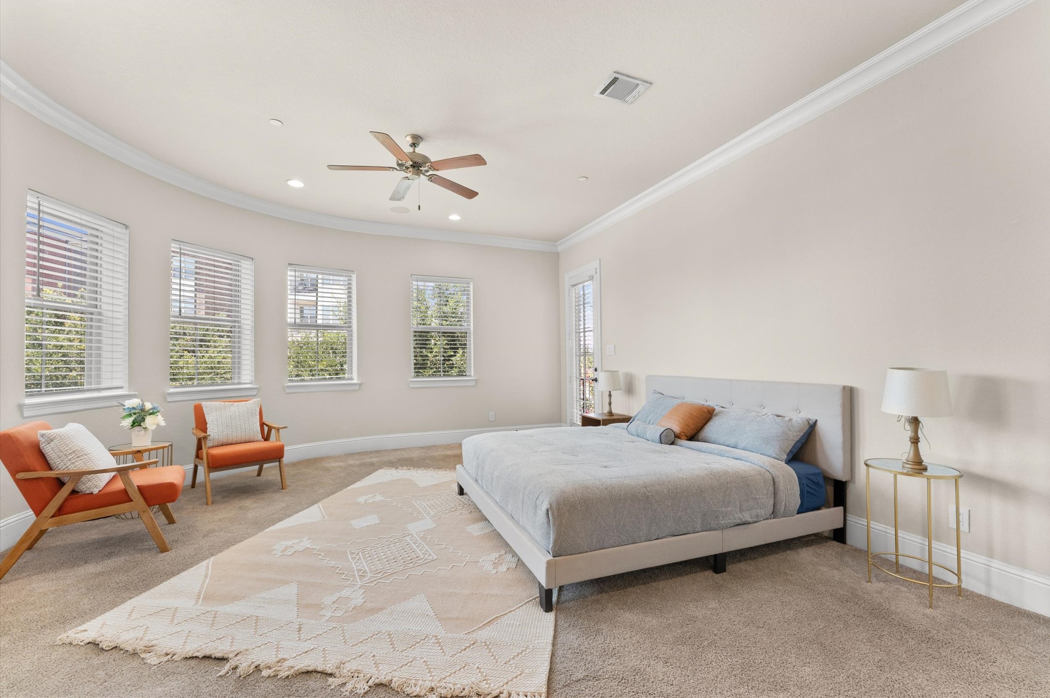 Spacious primary bedroom featuring a cozy sitting area, a private balcony, and a stunning bay window with a direct view of the fireworks.