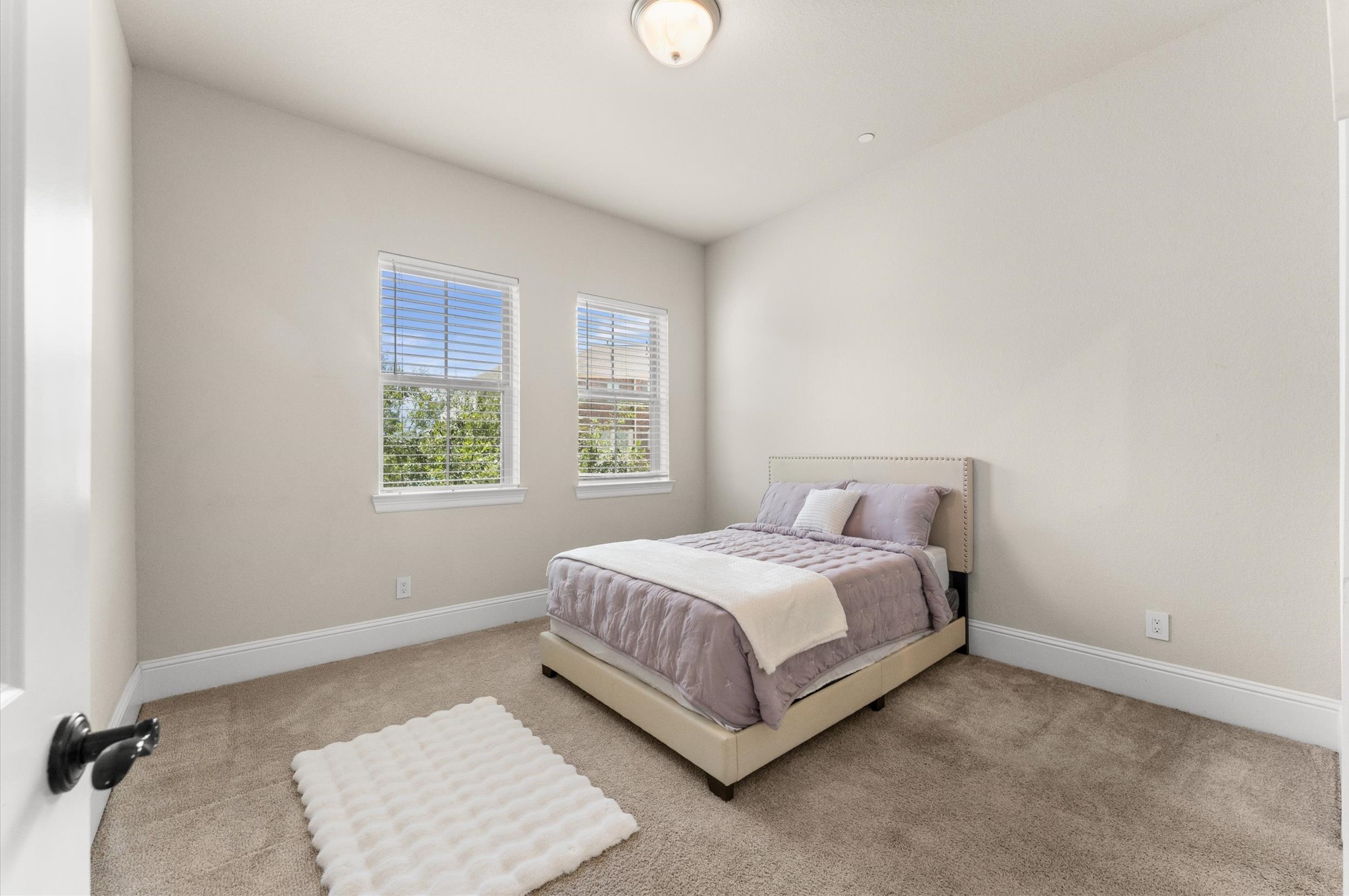 Spacious secondary bedroom featuring ample floor space and natural light.