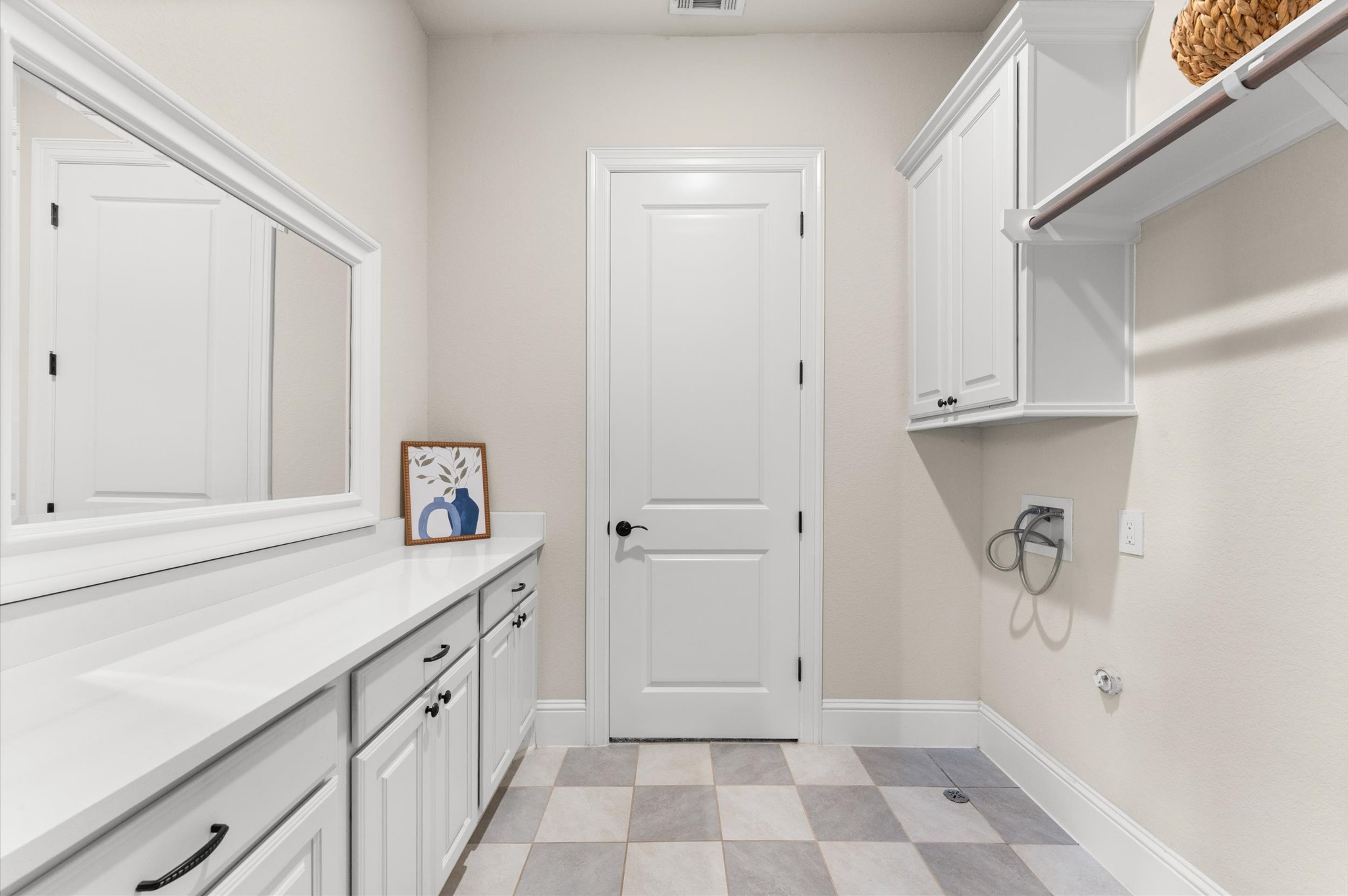 Upstairs laundry room with built-in storage cabinets.