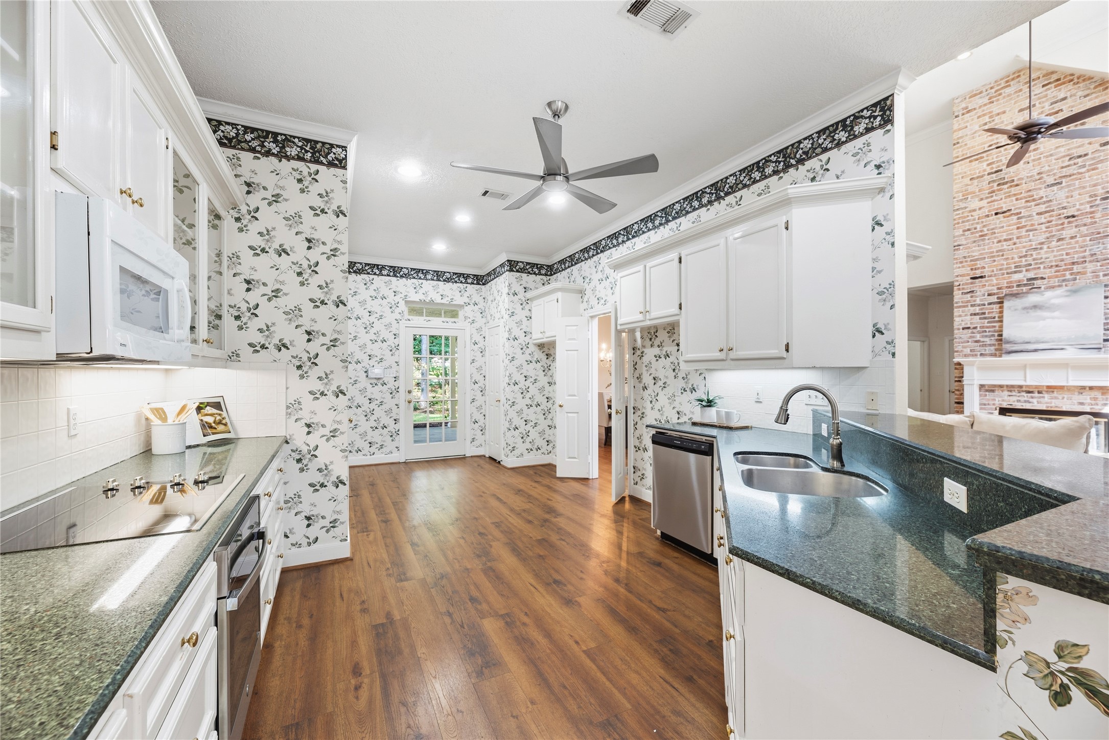 The kitchen connects seamlessly to the main living space, with generous counter space, abundant storage, and an open pass-through that keeps the rooms feeling connected.